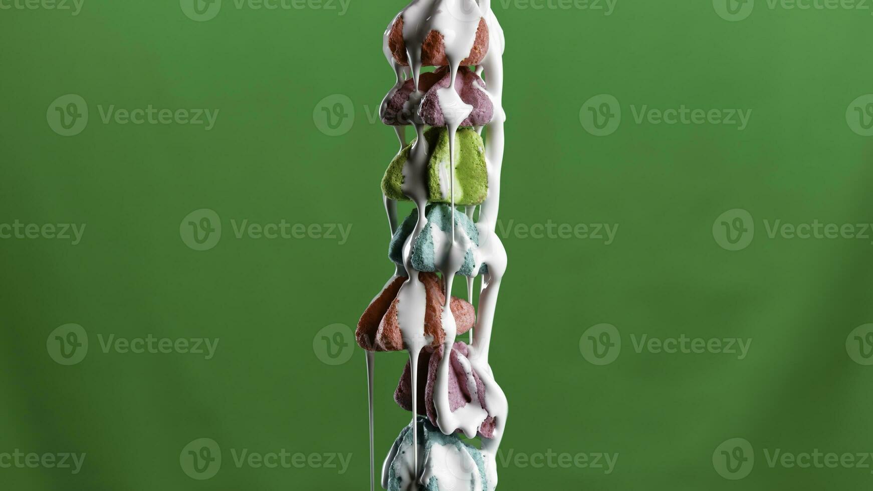 Close up of a lot of small meringues on a green chroma key background. Stock clip. Pouring white glaze on colorful meringue cakes, concept of confectionery. photo