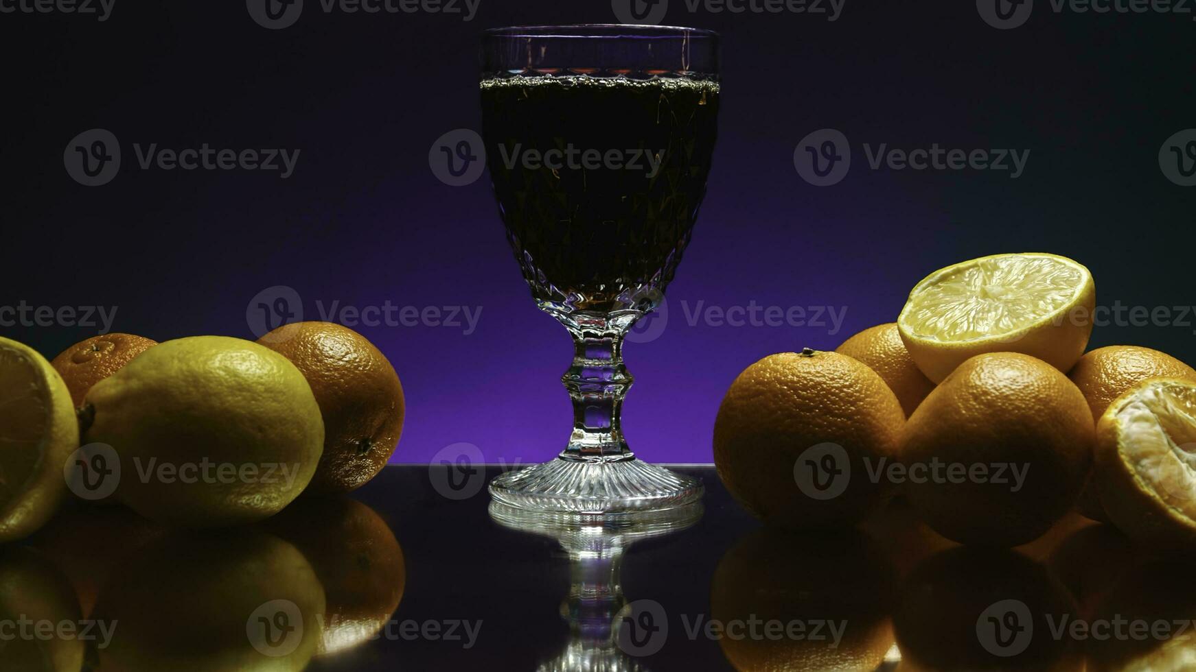 Dark drink with citrus fruits around. Stock clip. Drink with foam on background of citrus fruits and isolated background. Bar drink with citrus fruits photo