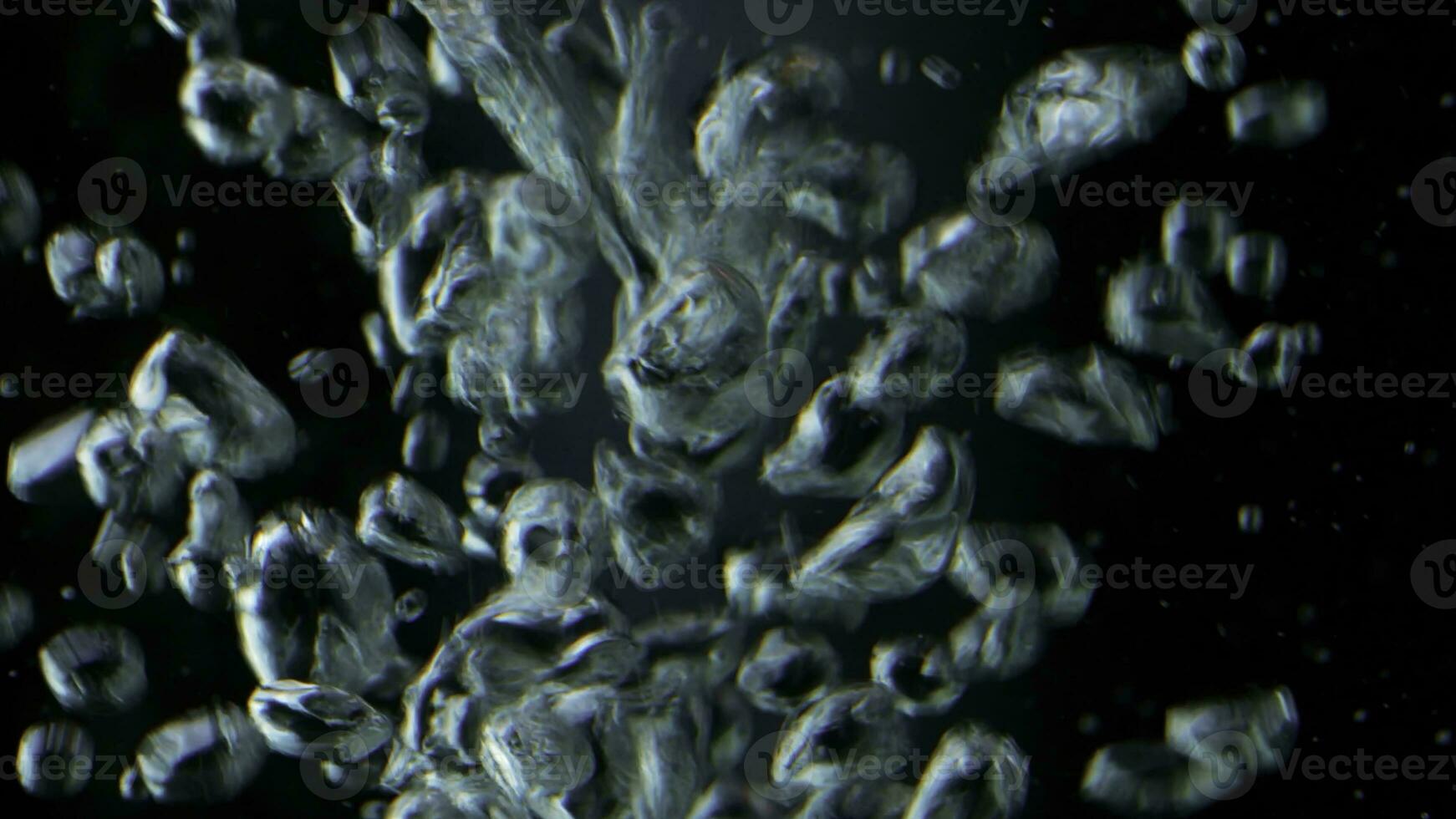 Close up of bubbles of air underwater on a black background. Stock footage. Boiling water macro view. photo