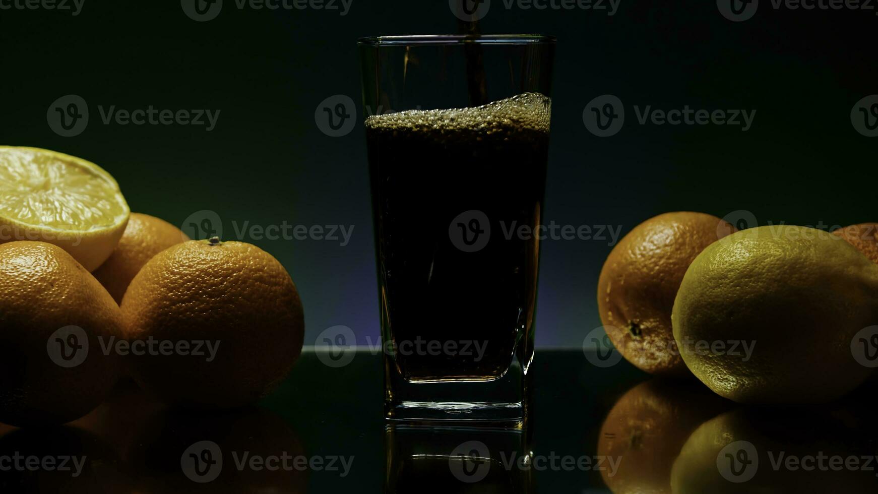 The concept of a bartender. Stock clip.Purple illuminated background with a large roomy glass in which soda is poured and the whole still life is decorated with light oranges photo