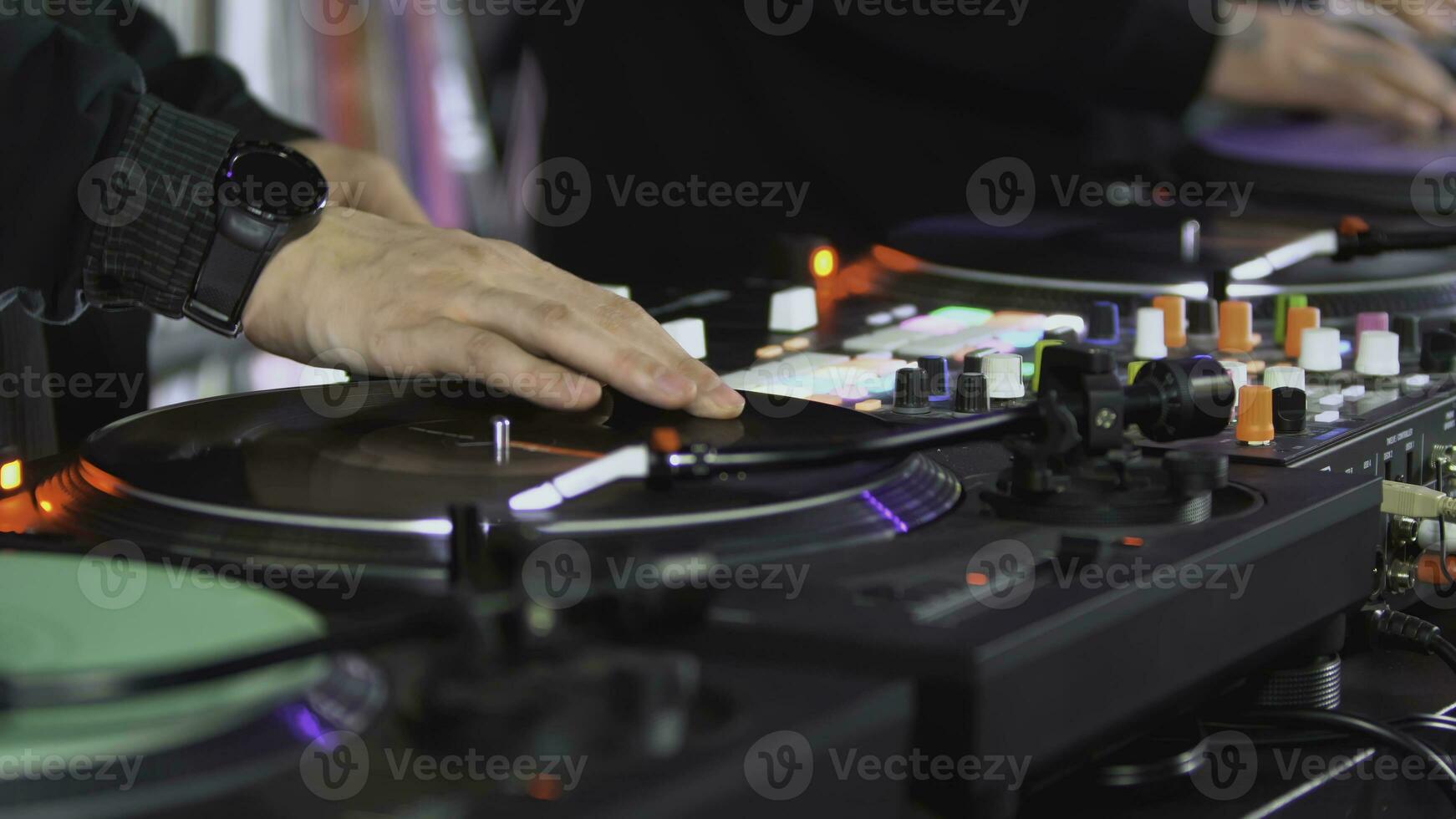 DJs play records at the disco. Art. Close-up of DJ's hand on the mixer. Glowing music panel at a party. The work of musicians in a nightclub photo