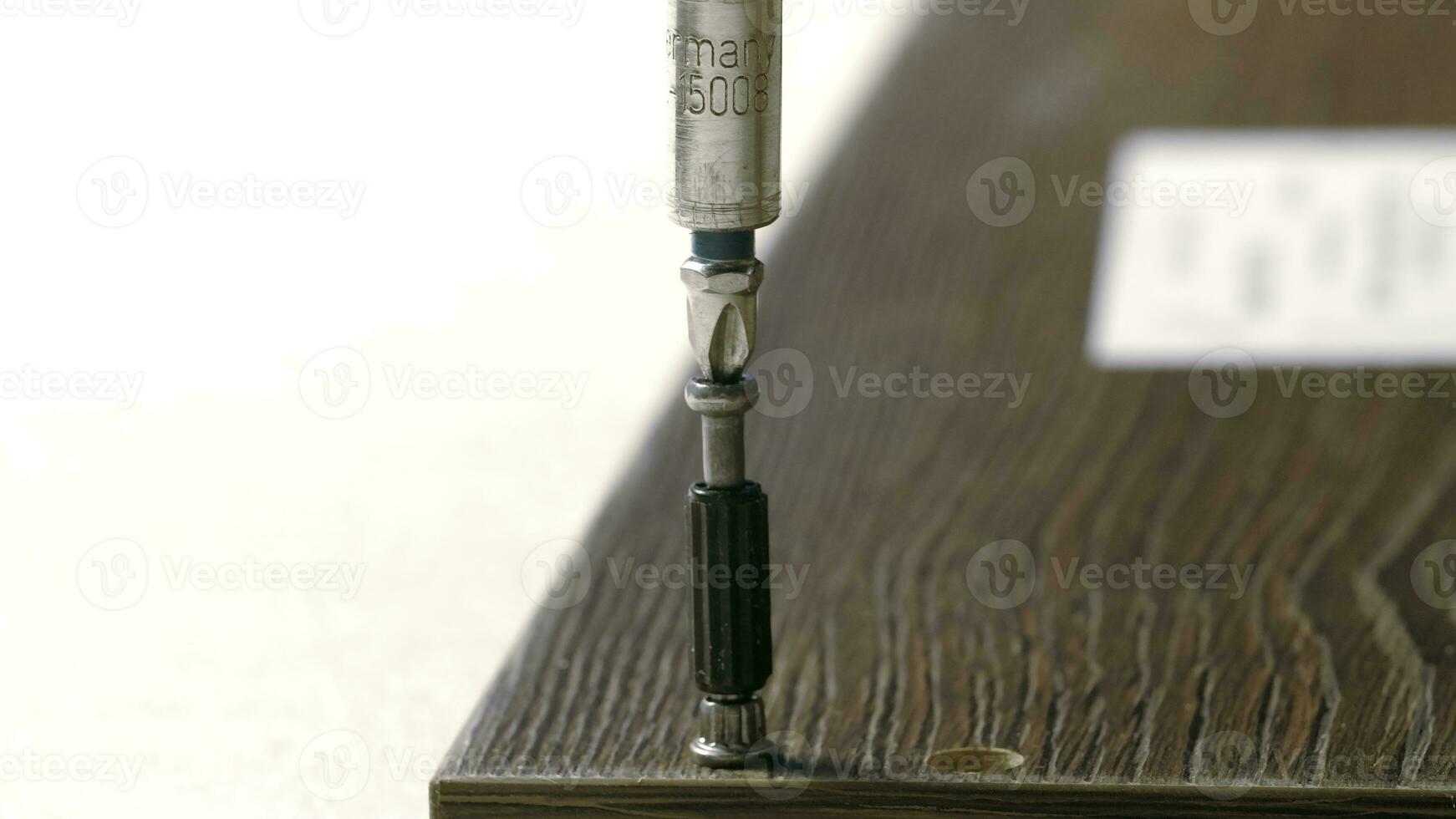 Repair work. Creative.A man collects a shelf by screwing bolts into it. photo