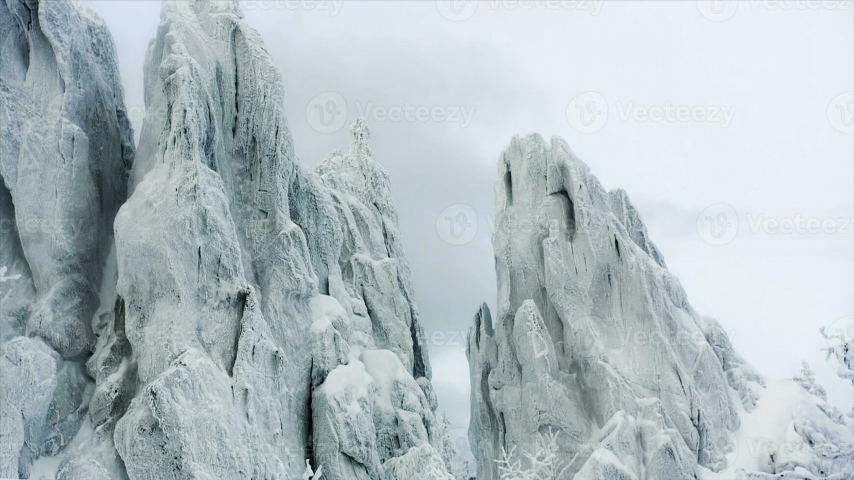 Nevado rock en el bosque. video. Nevado rocas en el montañas con claro cielo. Nevado montaña con plegable rock capas foto