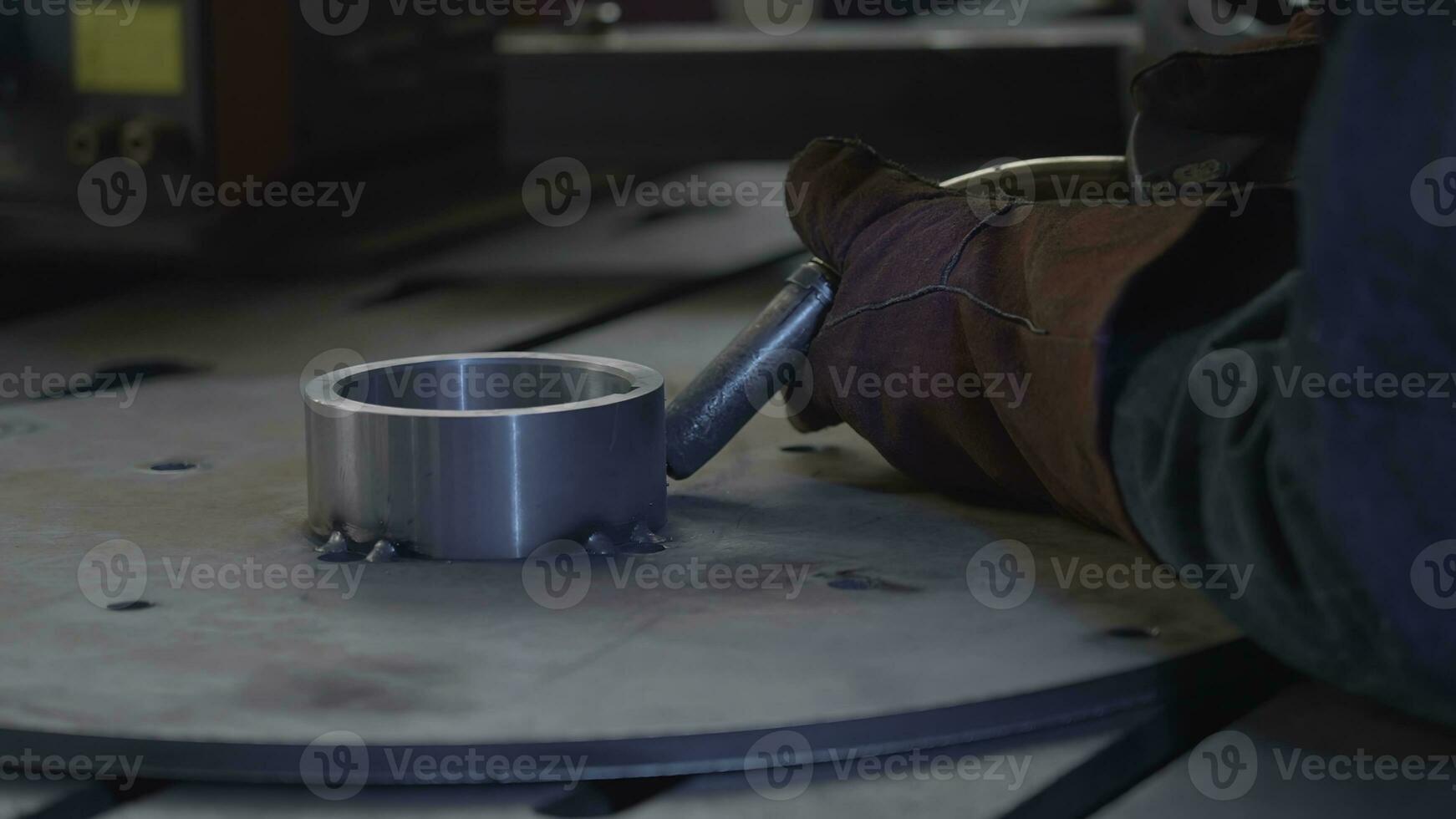 Welder in gloves holds welding with flying sparks. Creative. Sparks while working with welding and steel structures. Welding tube with sparks from metal structure photo