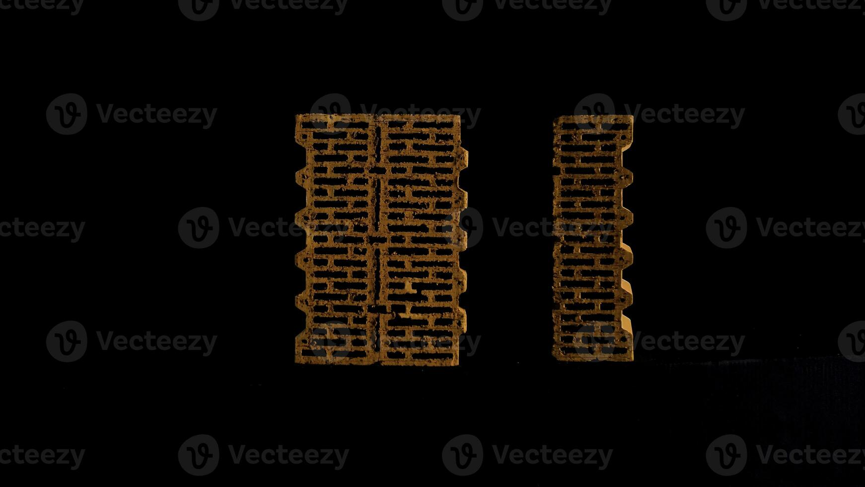 New red bricks isolated on black background, concept of materials at the construction site. Stock footage. Two perforated bricks moving against black screen. photo