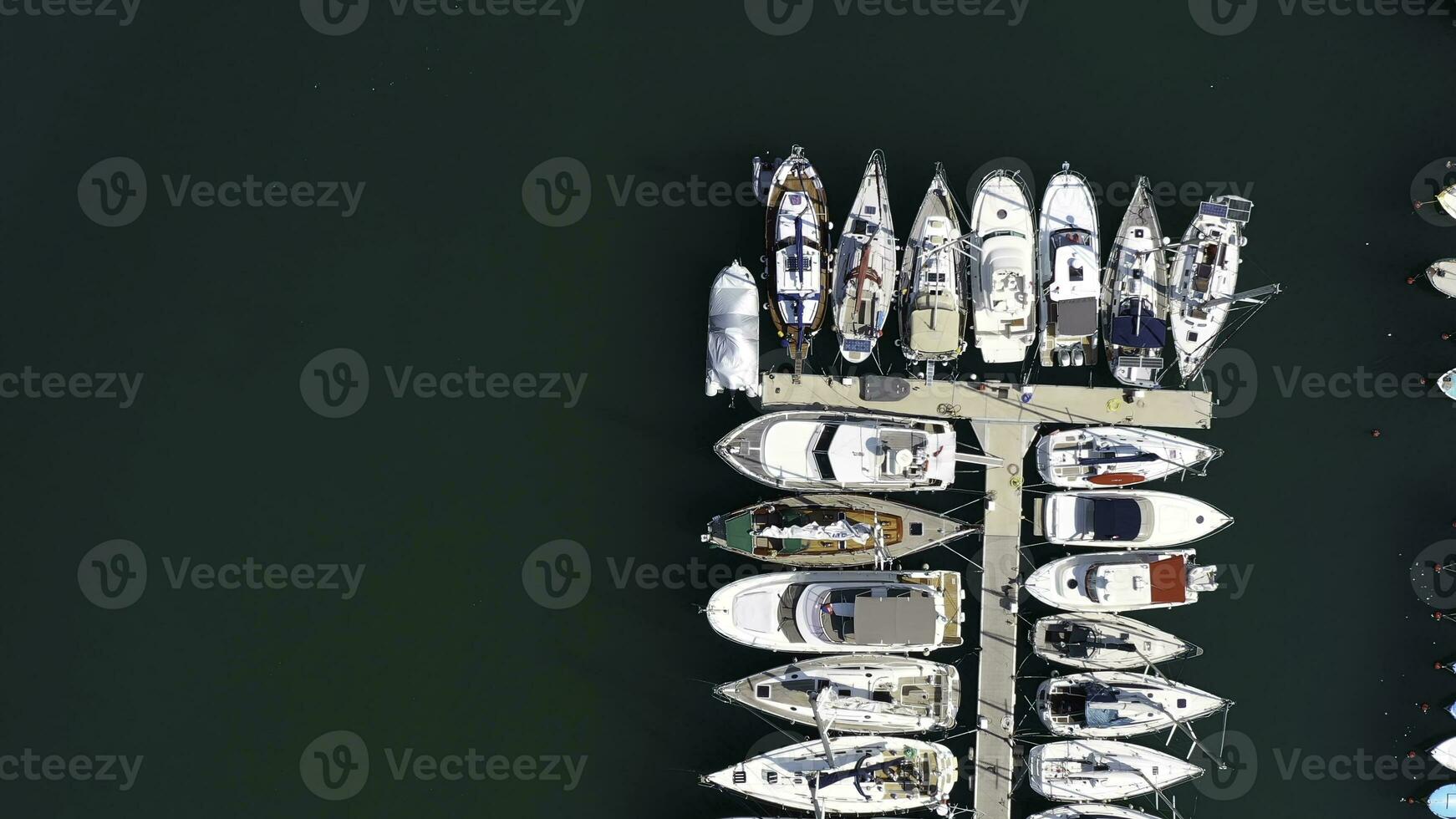 Aerial view of large and small yachts and sailboats moored at the quay. Action. Top view of Boats in Procida, Italy photo