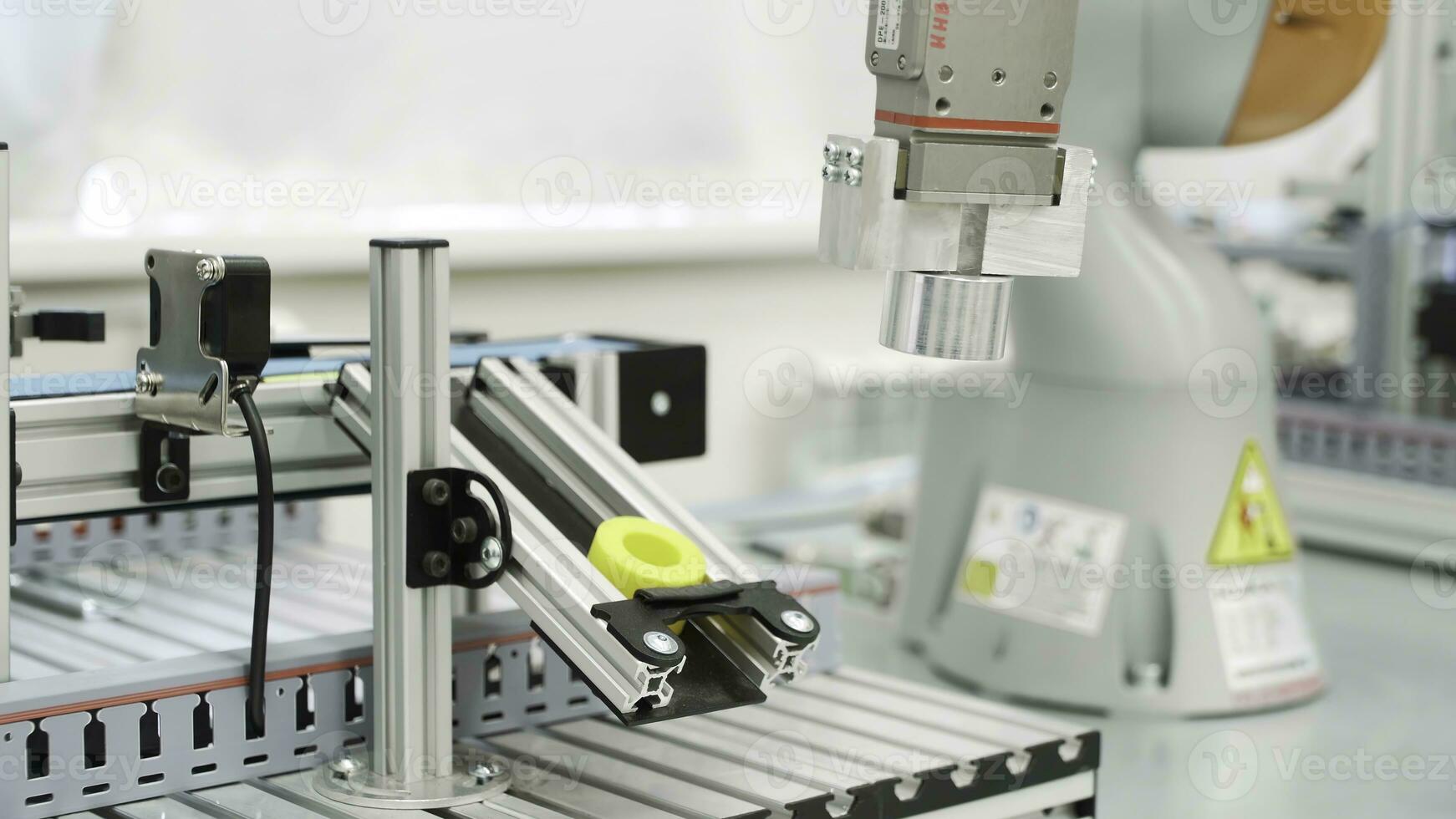 Close up of yellow object created by 3D printer in modern workshop. Scene. Technological background of robotic mechanism making a detail, science concept. photo
