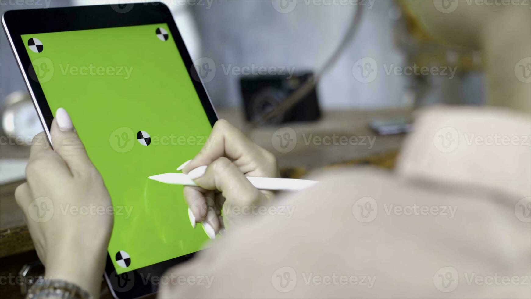 Hand draws a pencil on a tablet with a chromakey on the screen. Stock footage. Close up of a young woman drawing on a tablet with a green screen photo