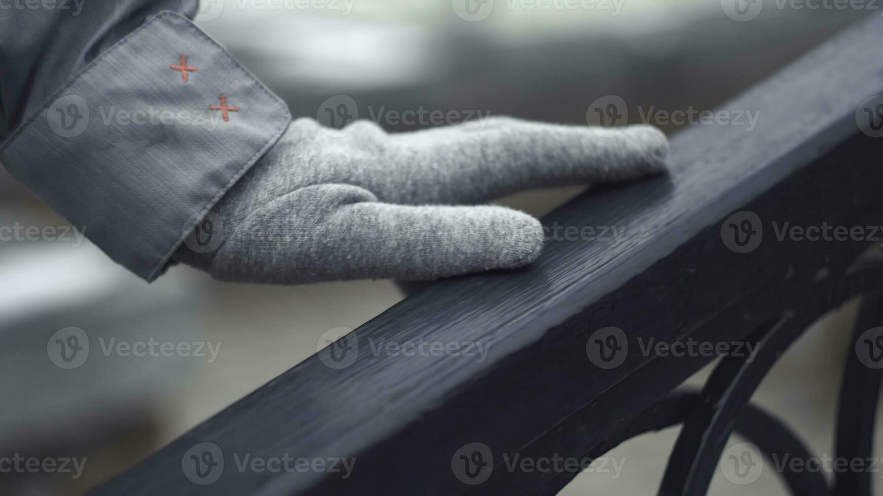 Close-up of young girl's hand sliding over railing. Hand in grey glove touches railing outdoors in cold weather photo