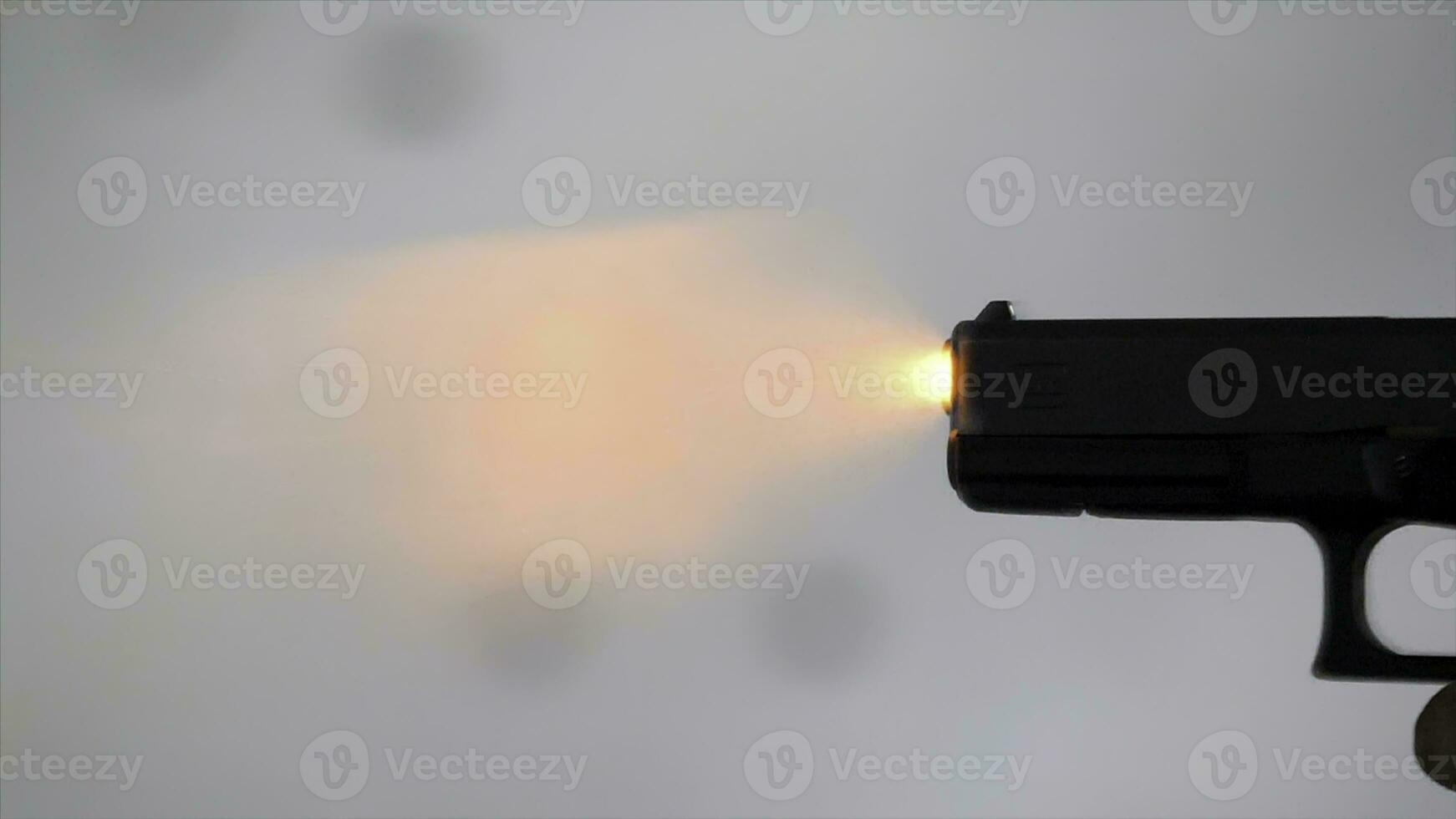 Close profile of man holding a 9 mm handgun, then takes a shot. Man fires hand gun at indoor shooting range. Close up. Man with 9 mm handgun takes a shot. Shot from above with an angle. Man holding a photo