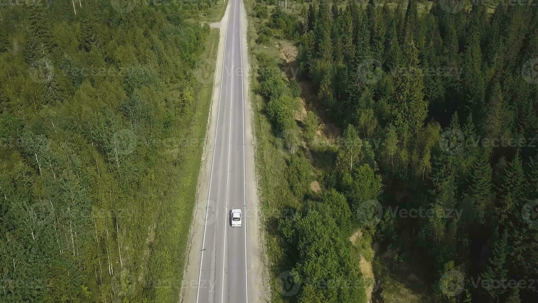 Top view scenic winding country road through green farmland. Clip. Aerial rural road countryside photo