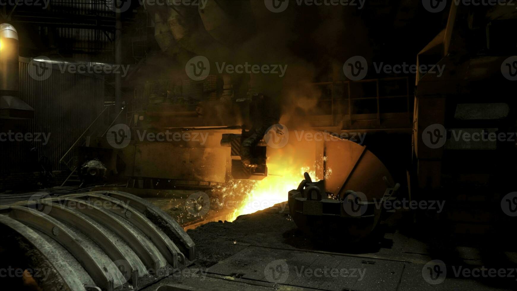 Molten iron flowing in a steel mill with many sparcles flying into the sides. Stock footage. Hot shop of the steelmaking factory with professional machinery. photo