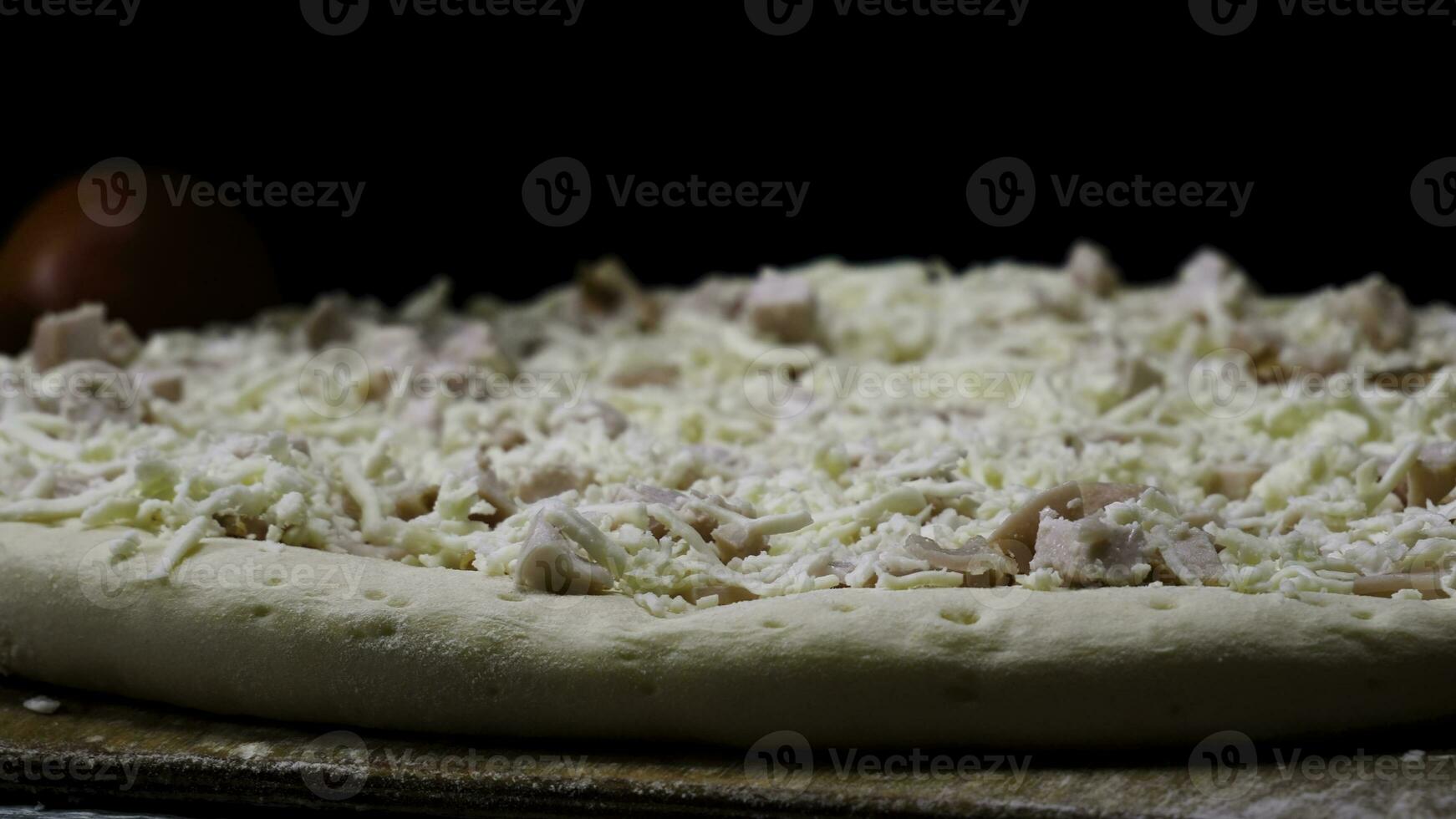 cerca arriba para cocinero manos en transparente guantes conmovedor sin hornear Pizza en negro fondo, Cocinando concepto. marco. hombre en Cocinando guantes preparando Pizza para horneando. foto