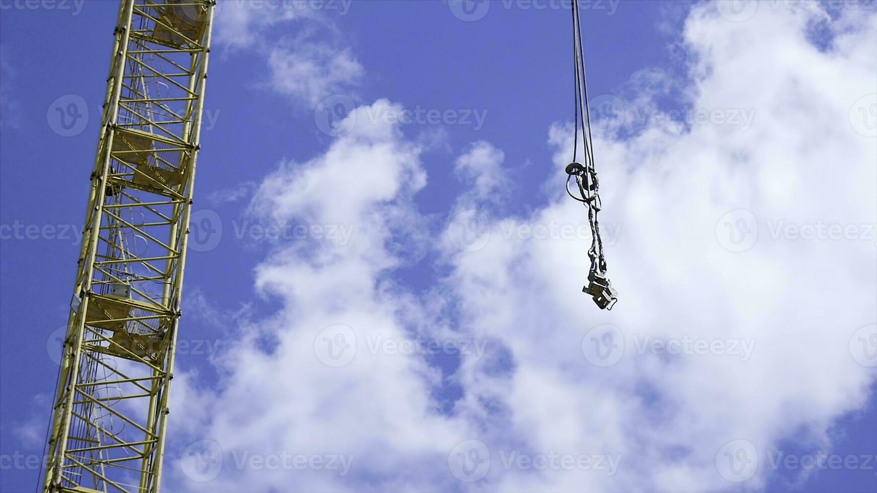 close up of a yellow and green crane boom with main block and jib against a clear blue sky. Tower building cranes against the sky photo