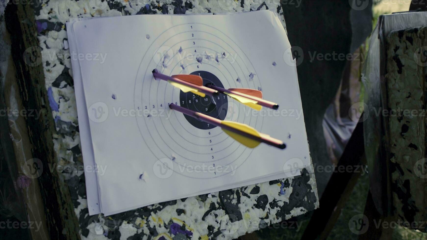 Close up of archery target on green wooden boards background. Clip. Target, bow and quiver with arrows on a green lawn for training in shooting photo