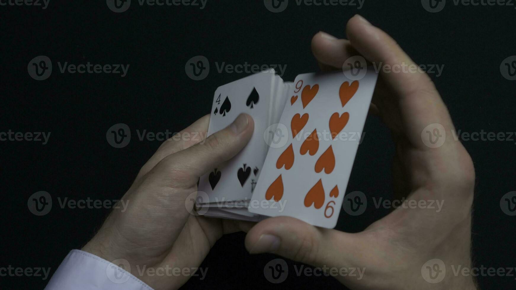 Poker game - shuffling cards. Man's hands shuffing cards. Close up. Man's hands shuffling playing cards. Dealer's hands shuffling cards during a poker game photo