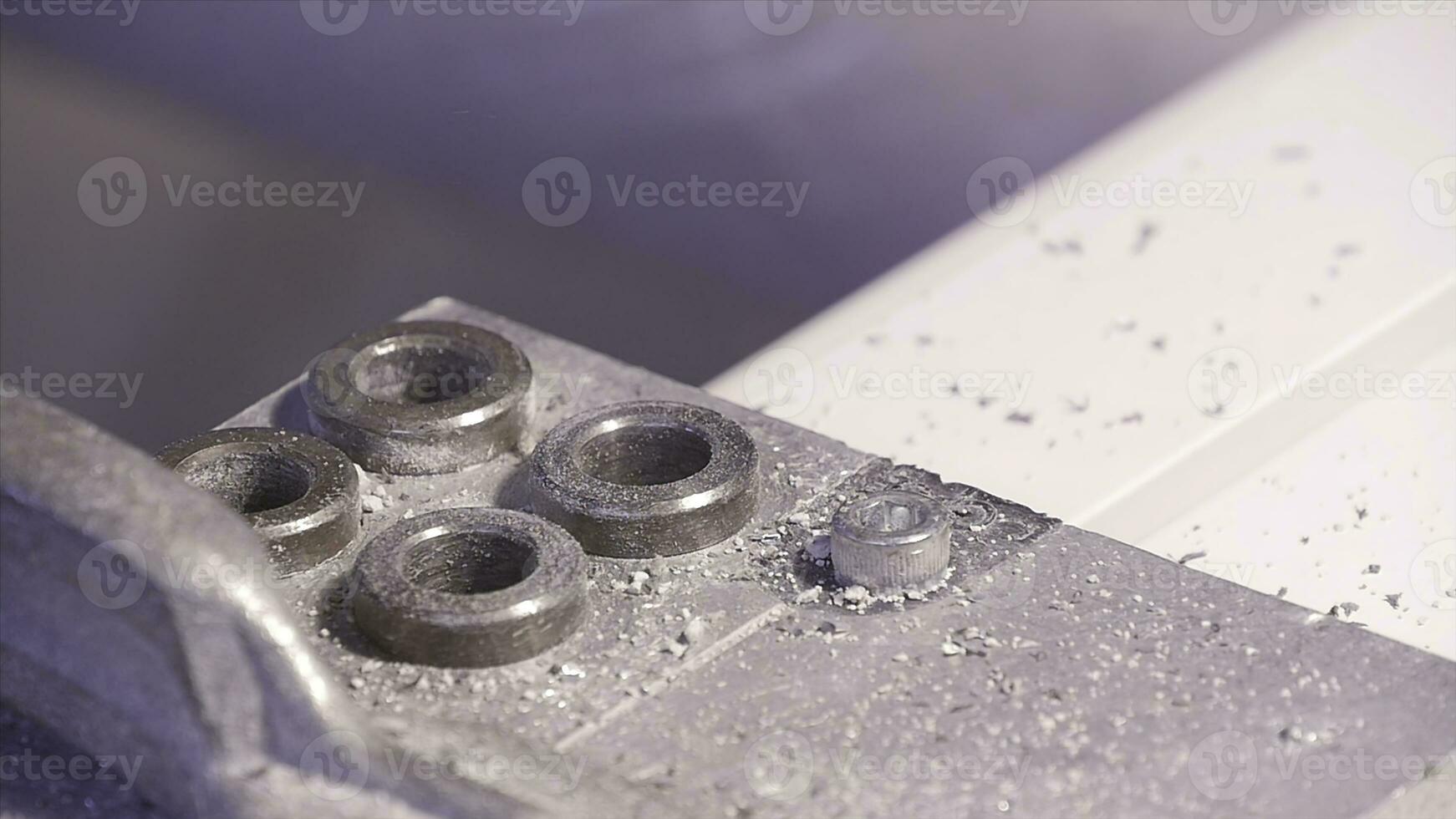 Hole being drilled into aluminium and metal using electric drill. Aluminium or metal drilling closeup in metal workshop with electric drill. Employee drilling in flat steel plate with bench drill. photo