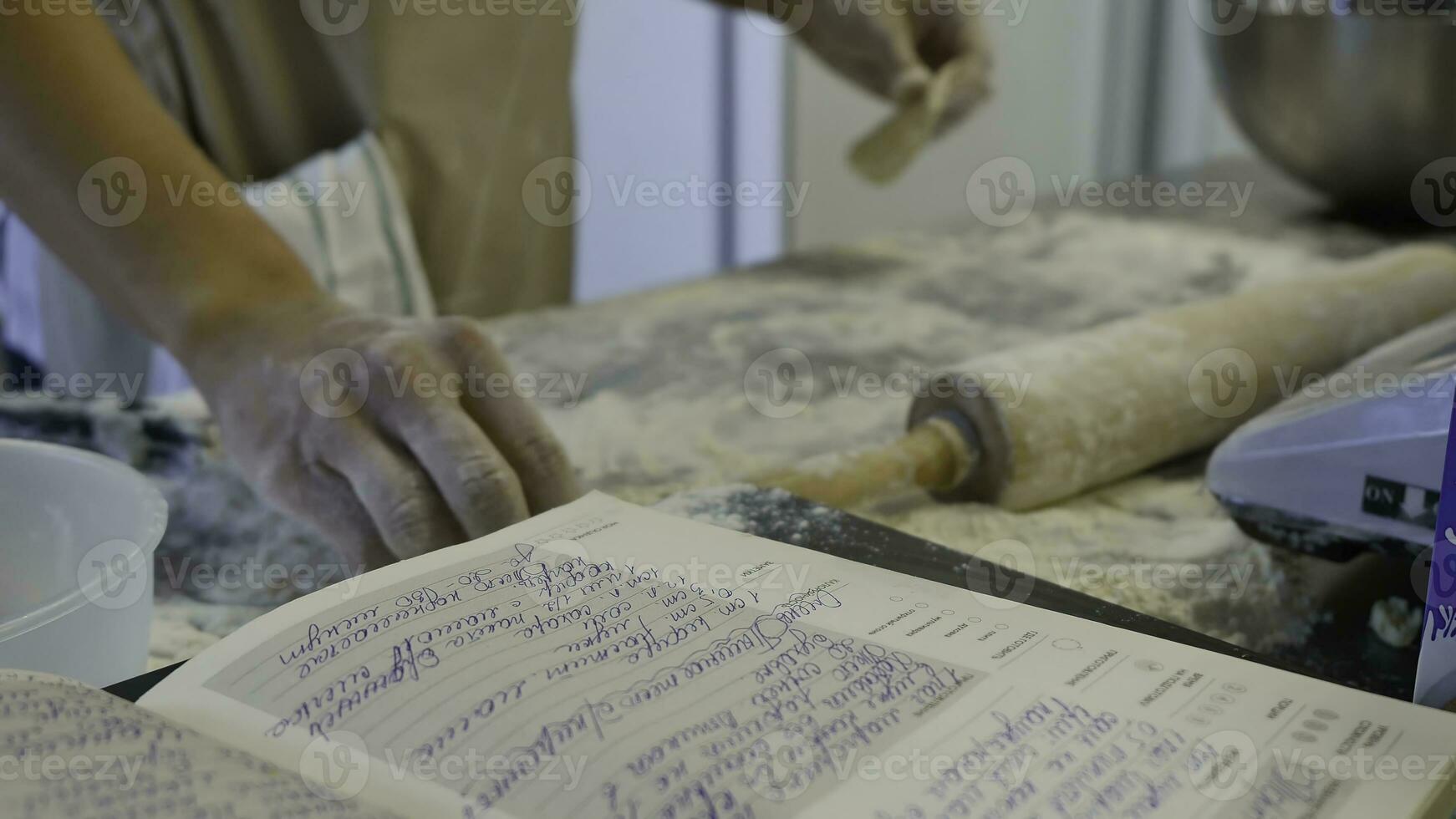 Detail of woman's hand rolling out a dough with a rolling pin while making homemade pasta. Woman's hands rolling dough photo