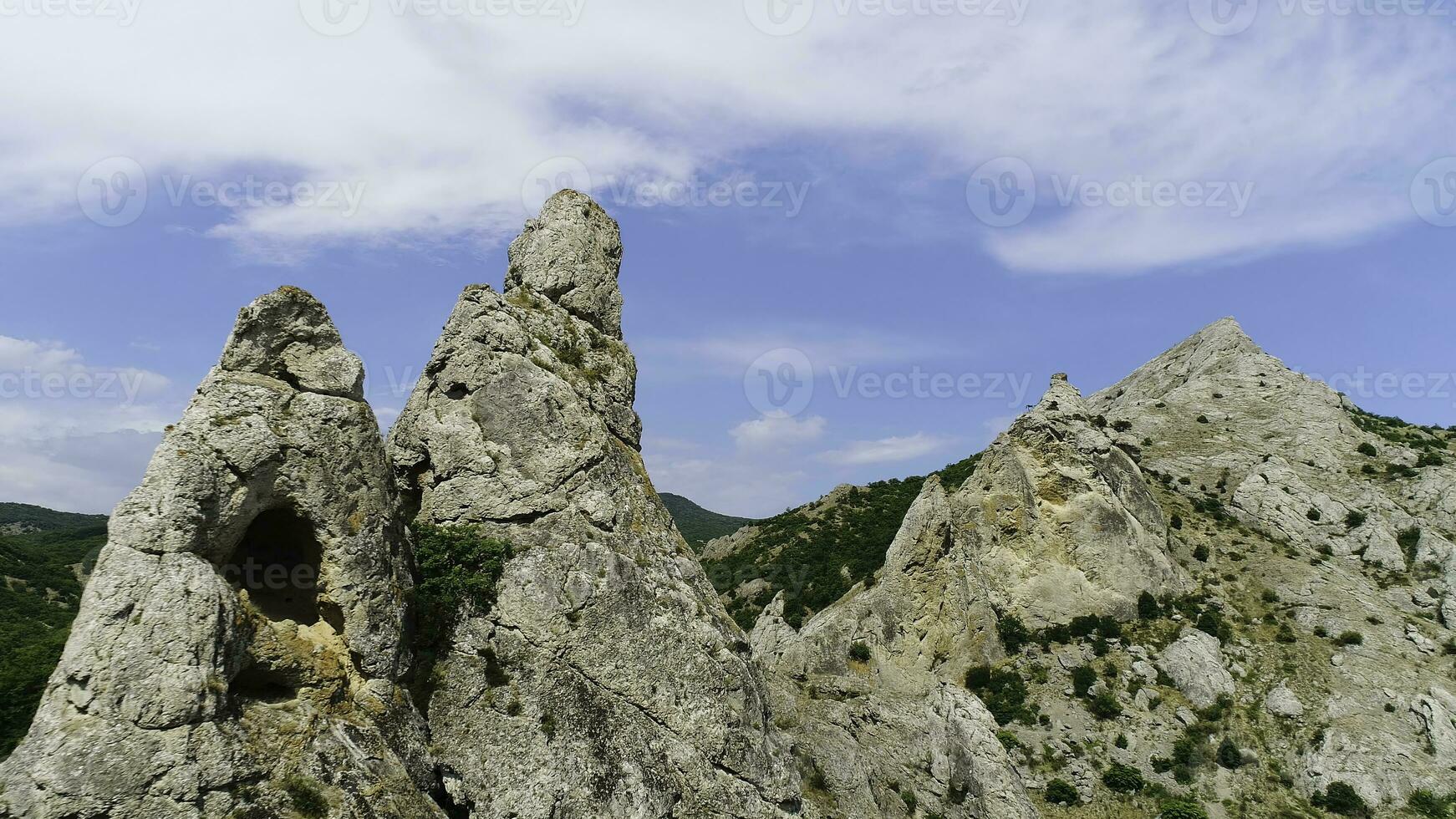 Beautiful green mountain landscape with green trees and rocks on blue cloudy sky background. Shot. Aeial view of forested hills in a summertime. photo