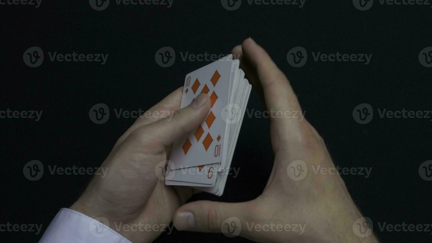 Poker game - shuffling cards. Man's hands shuffing cards. Close up. Man's hands shuffling playing cards. Dealer's hands shuffling cards during a poker game photo