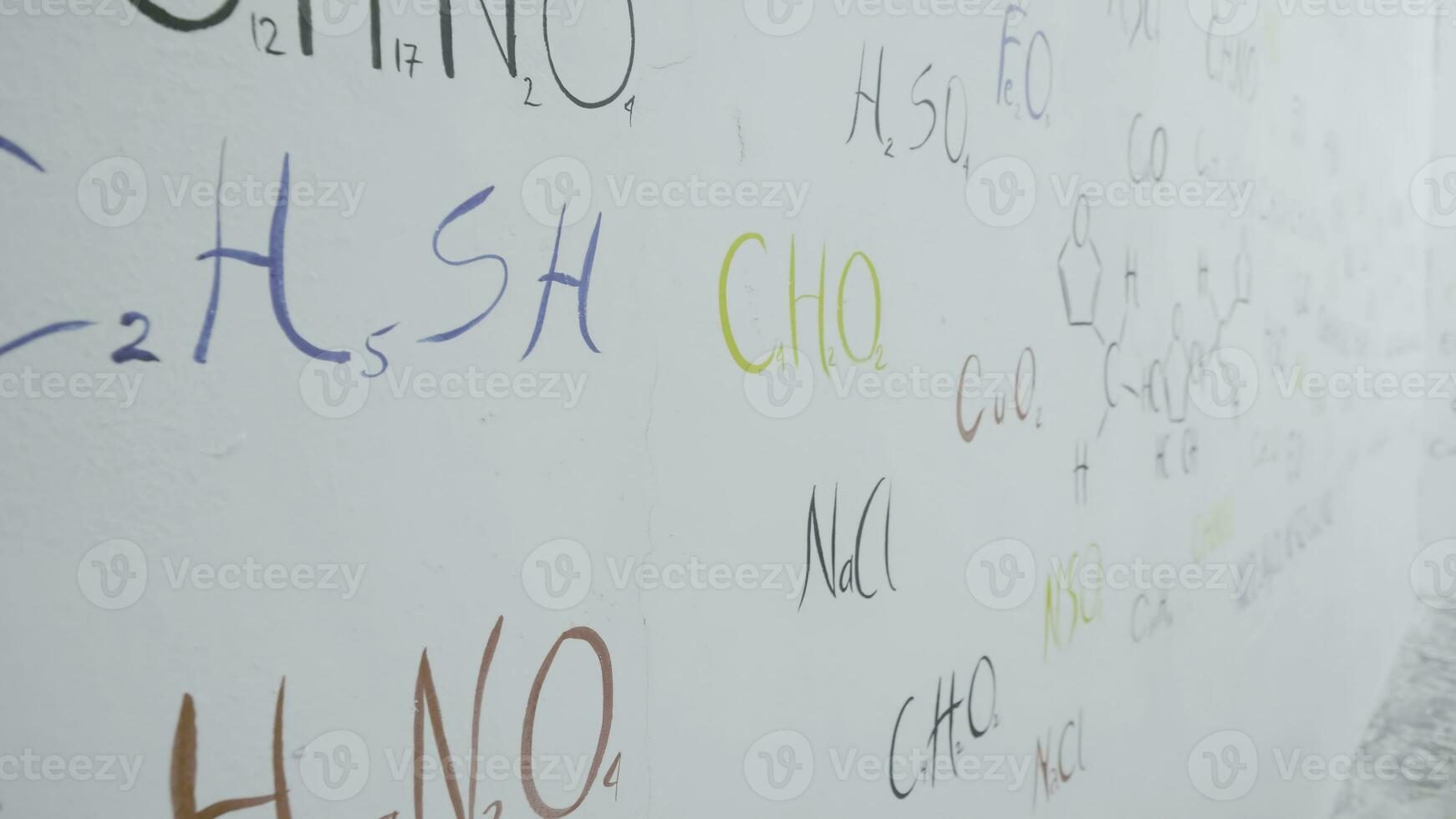 vistoso fórmulas de el químico elementos en blanco pared. químico fórmulas escrito en blanco pizarra antecedentes. químico tema. foto