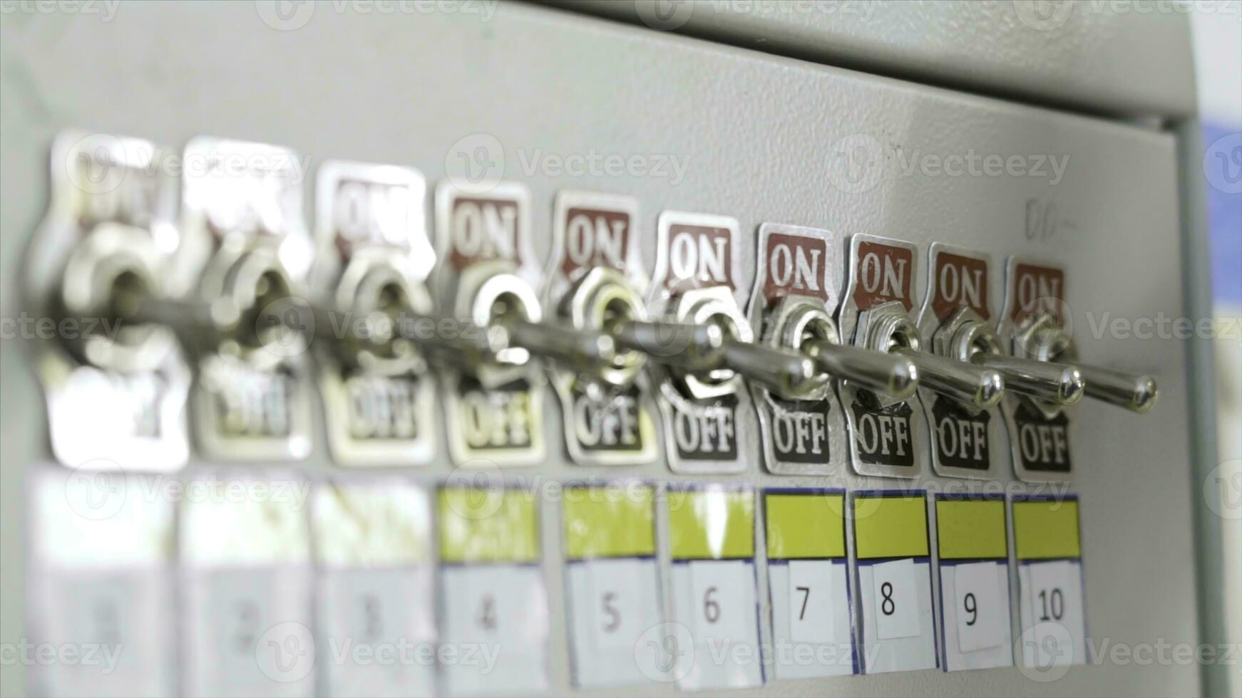 Close-up of fuse switch panel. Action. Manual panel with toggle switches on factory fuse. Hand of factory worker switches toggle on brush photo