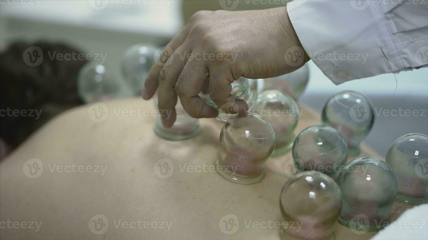 Massage vacuum banks. Close-up of man lying with banks on his back in spa salon. Vacuum banks in treatment and cosmetology photo