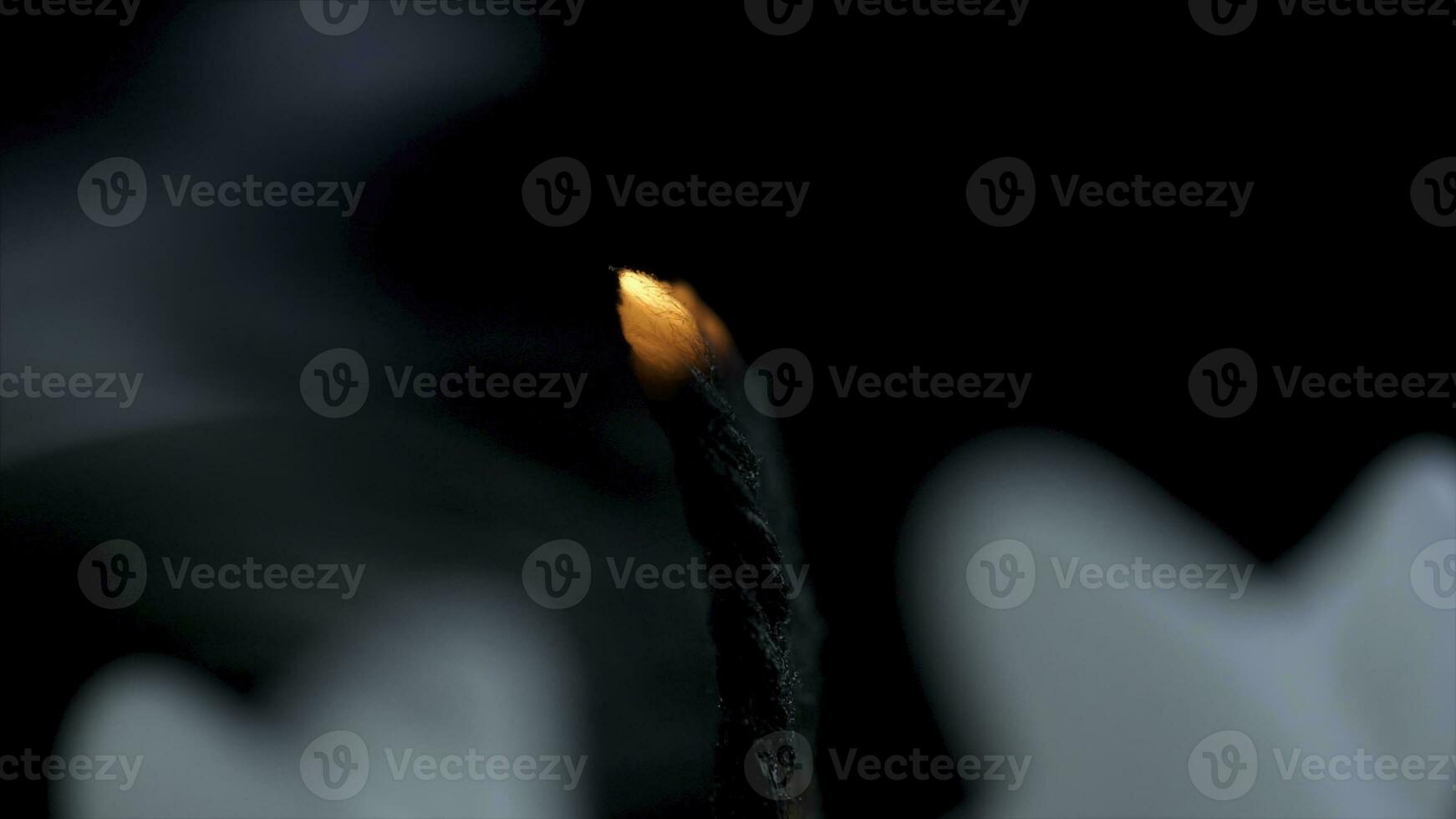 White long candle on black background. Single candle flame light. Long flame, old candle. White candle, black background. White glossy cylinder unlighted isolated on a dark background photo