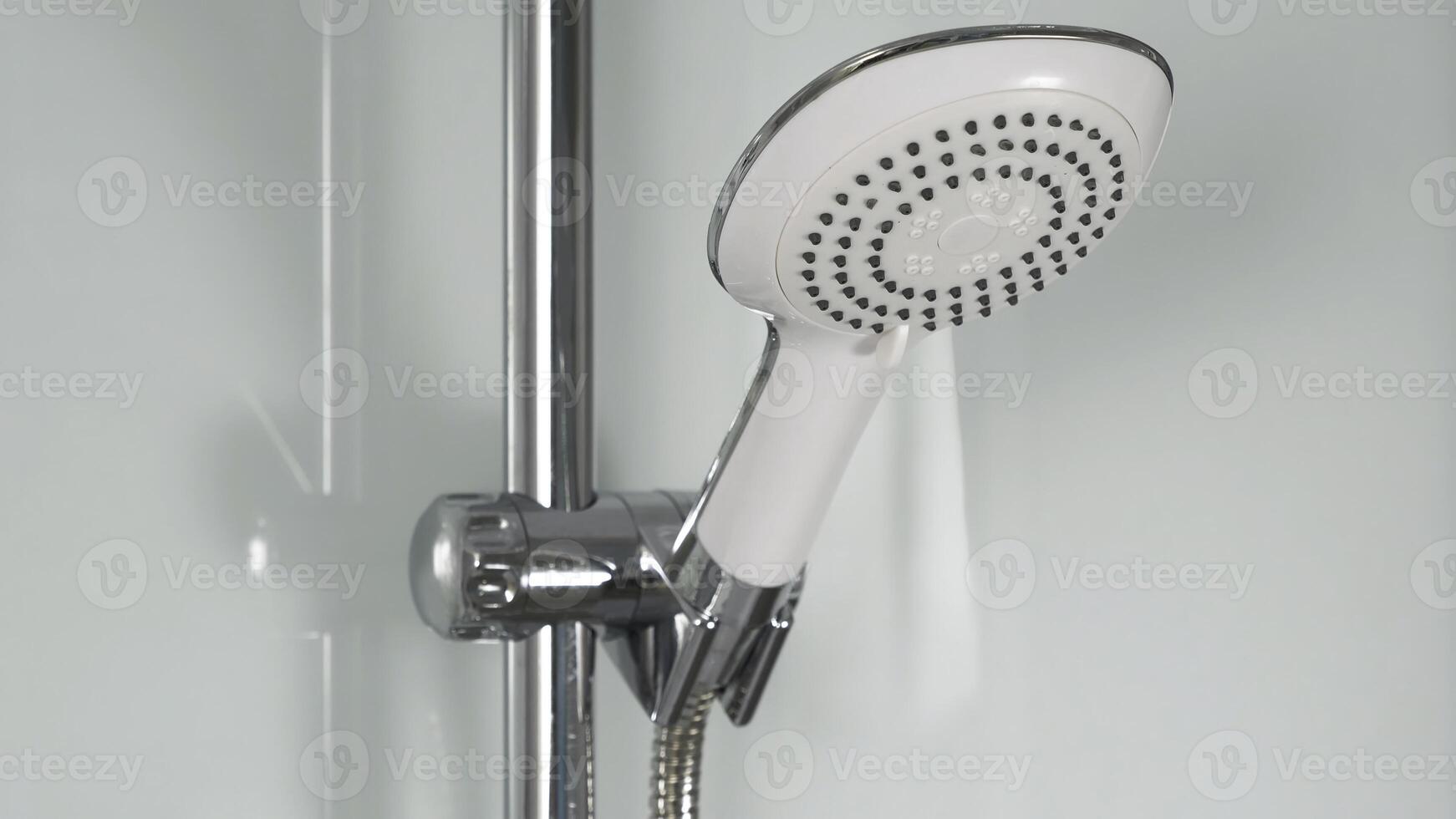 Chrome shower. Bath shower on white tile wall. Shower head isolated on white shower cabin photo