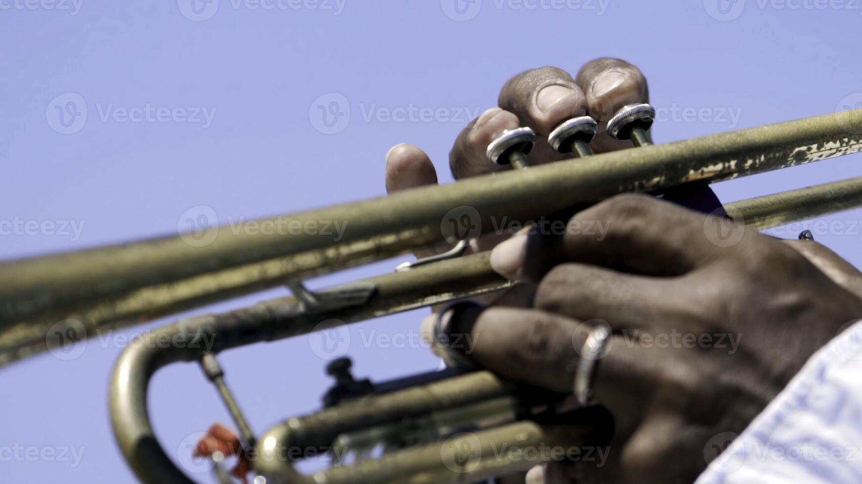 Detail of a man's hands playing a trumpet. Action. Close-up of a black man's hands playing the trumpet photo