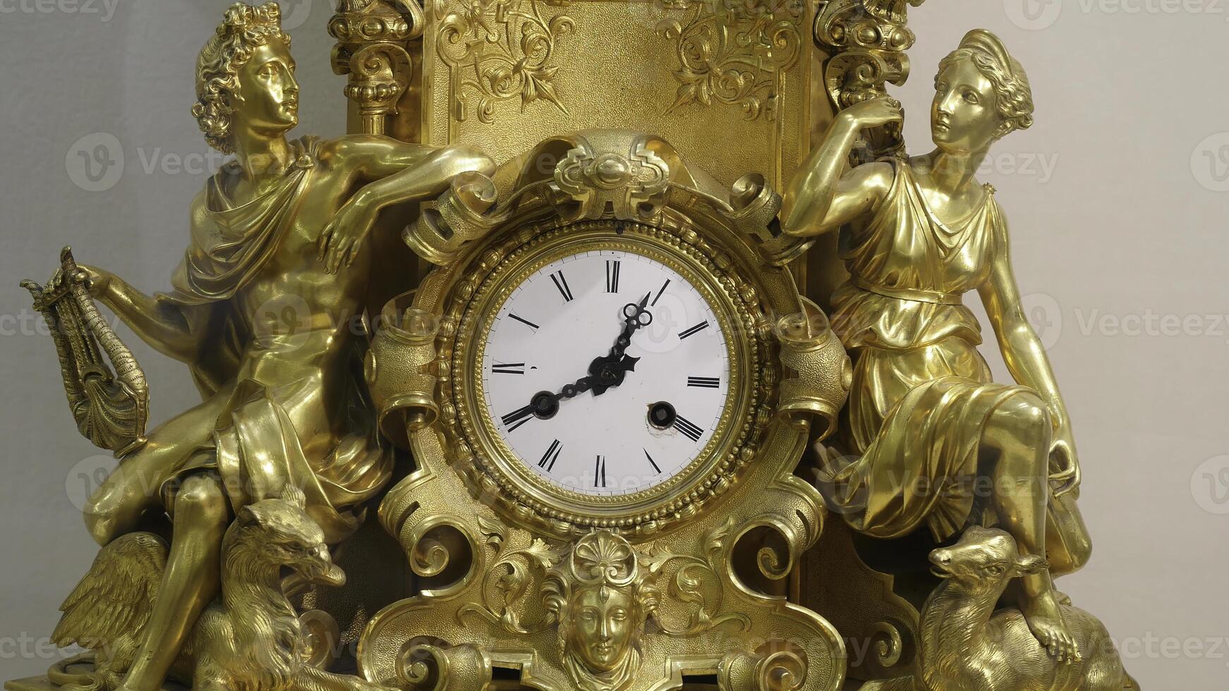 Ancient vintage brass pendulum clock. Vintage gold watch photo