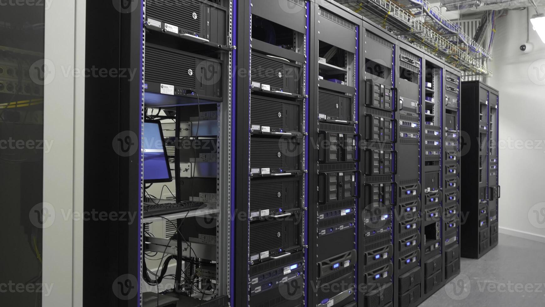 Many powerful servers running in the data center server room. Many servers in a data center. Many racks with servers located in the server room. Bright display a plurality of operating equipment. photo