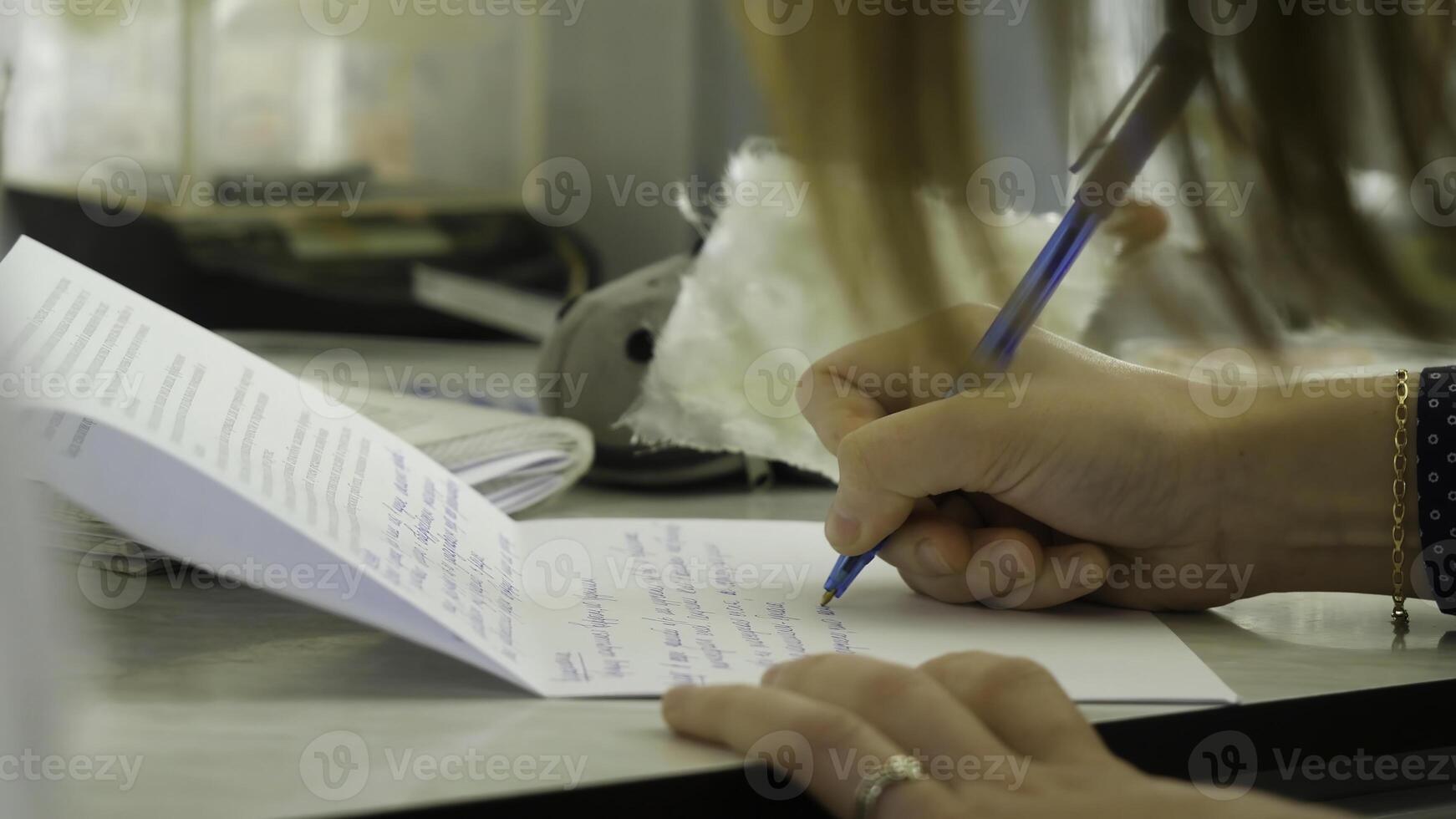 Closeup of a female hand writing on an blank notebook with a pen. Close-up of a female hand writing on an blank notebook with a pen photo