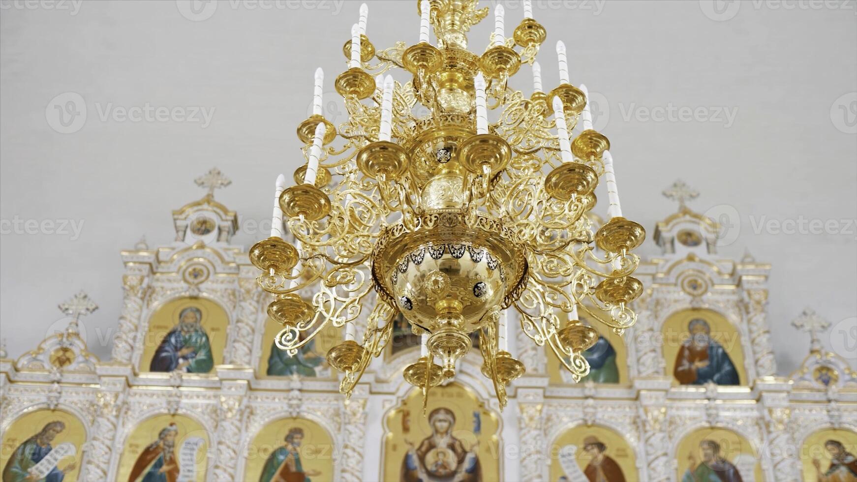 cristiano ortodoxo Iglesia interior en blanco y dorado colores. video. candelabro con artificial velas en el templo con iconostasio. foto