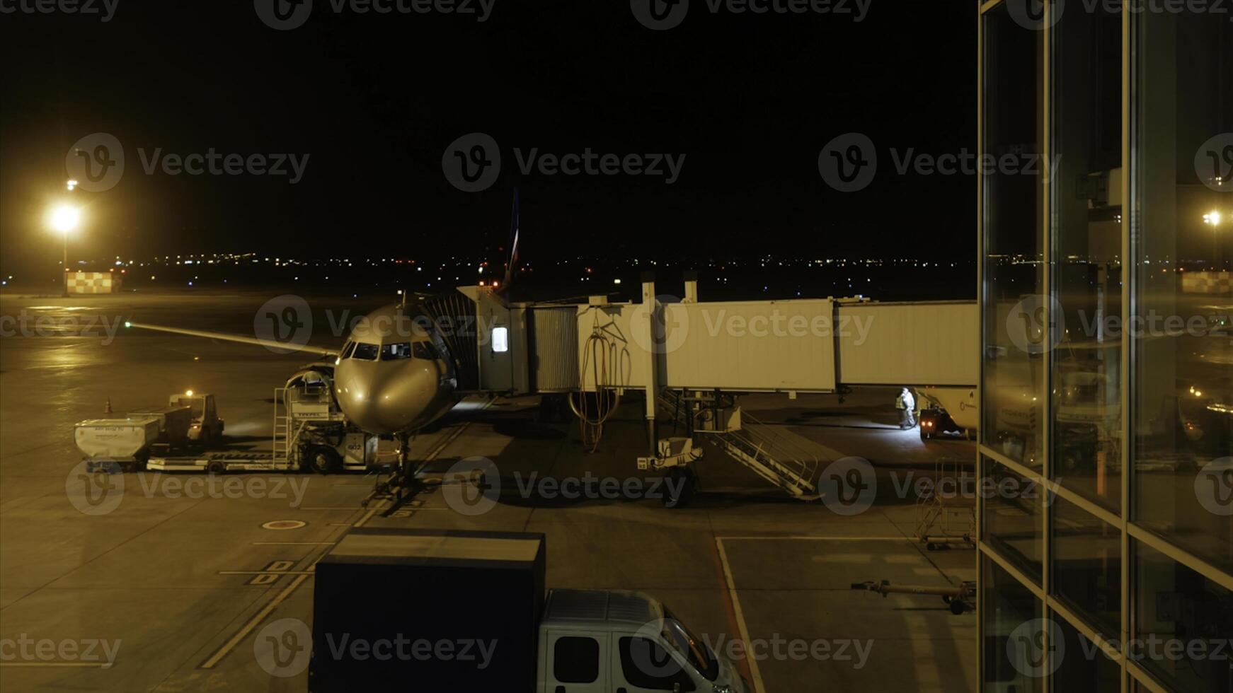 Close view of aircraft fuselage near the entering baggage door, at night. Plane takes passengers. Timelapse photo