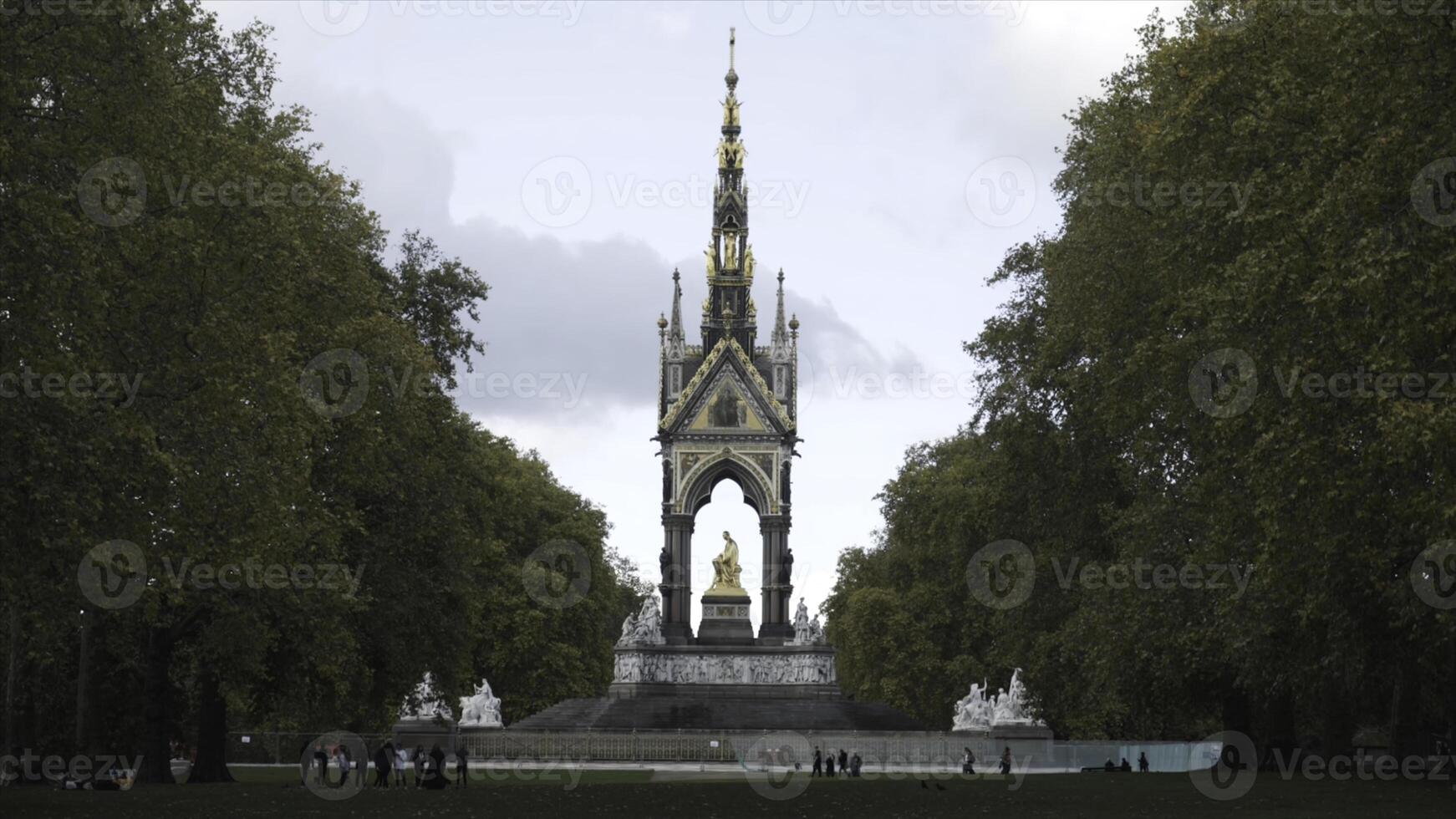 hermosa ver de el dorado Albert monumento rodeado por grande verde arboles en Kensington jardines, Londres, Reino Unido. acción. Inglaterra puntos de referencia foto