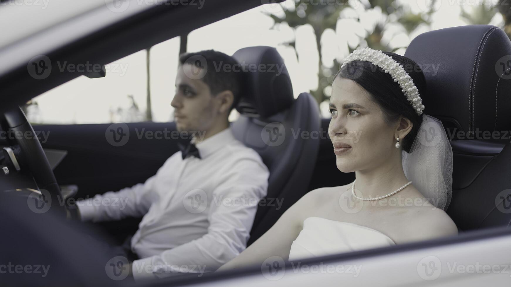 Beautiful couple in convertible. Action. Beautiful couple in festive elegant outfits in car. Couple in love in convertible on sunny summer day photo