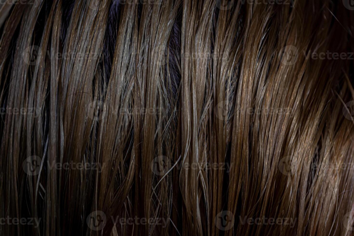 Close up background of wet female hair after bathing with shampoo, warm brown colors. photo