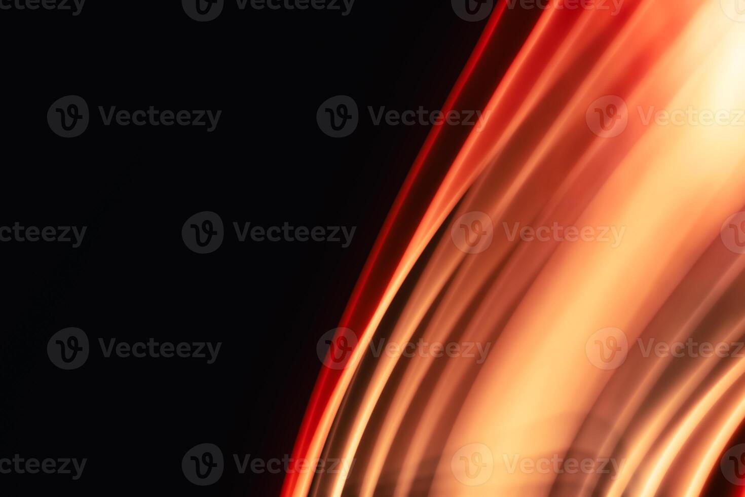 Abstract red-orange uneven diagonal waves glowing on black background with space for text. photo