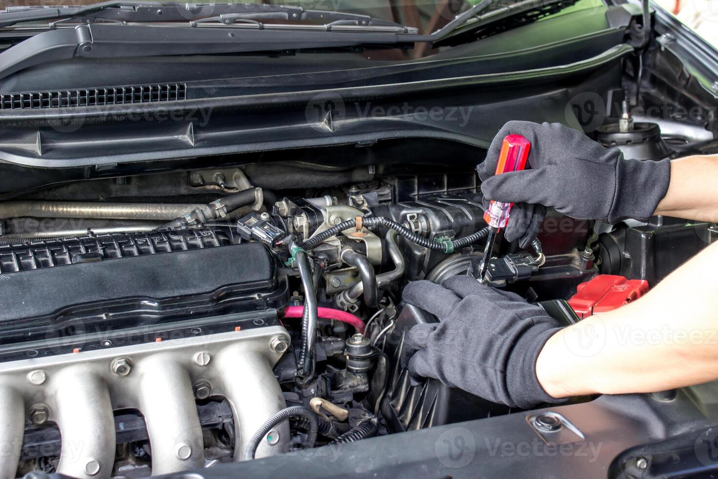 técnico utilizar destornillador eliminar un tornillo de flujo de aire sensor en el motor habitación coche para cheque y limpieza en Servicio concepto foto