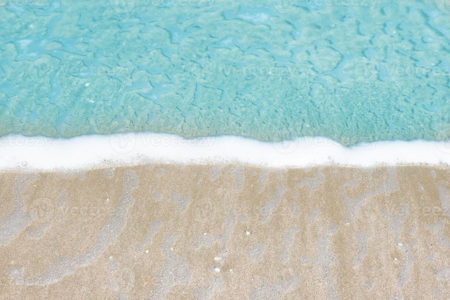 Sea wave and bubble on a sandy white beach blue sea background texture and copy space photo