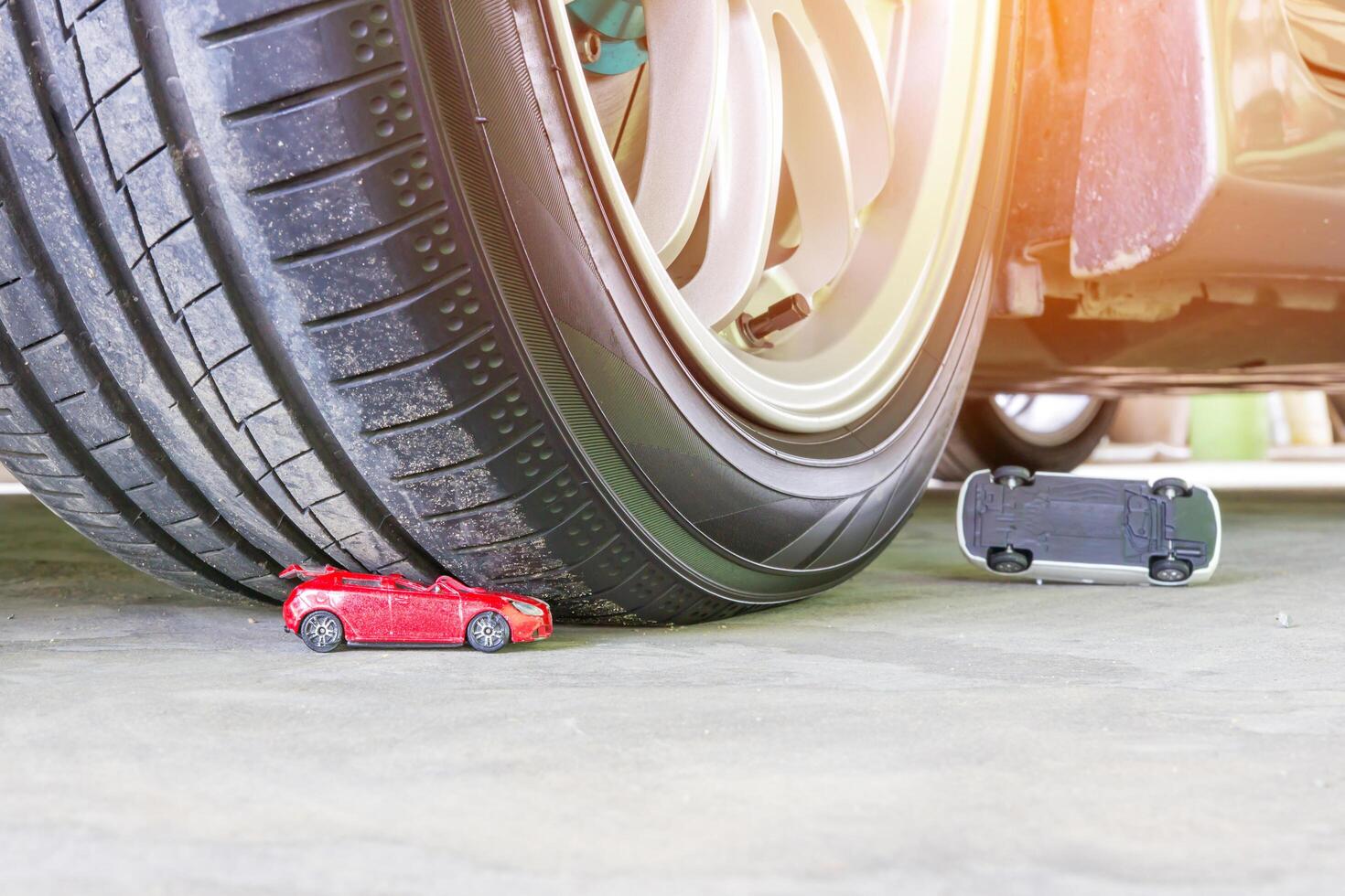 Toy car accident concept with wheel of car toy on cement floor photo