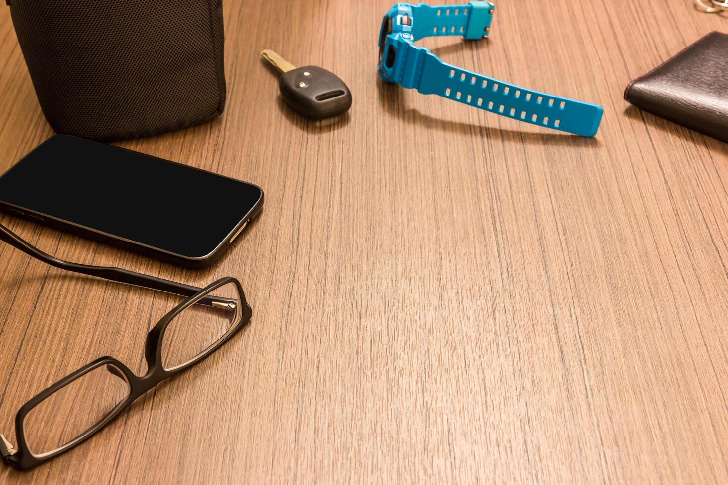 Glasses smart phone Watch key car wallet on the wood table in hotel holiday concept photo