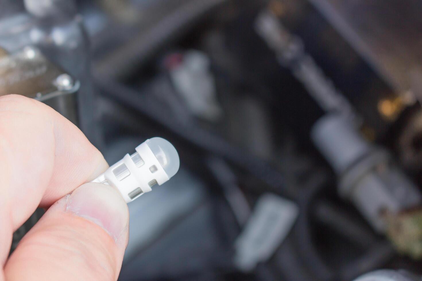 Close up Light bulb LED of Car and hand a man change and maintenance ramp of Lighting system signal photo