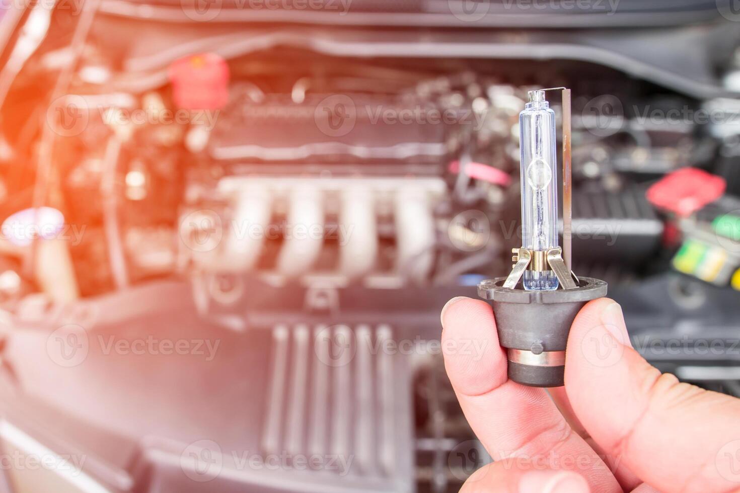 cerrar los faros de los automóviles equipo de iluminación de xenón en la mano un hombre con sala de máquinas para el concepto de mantenimiento del automóvil foto