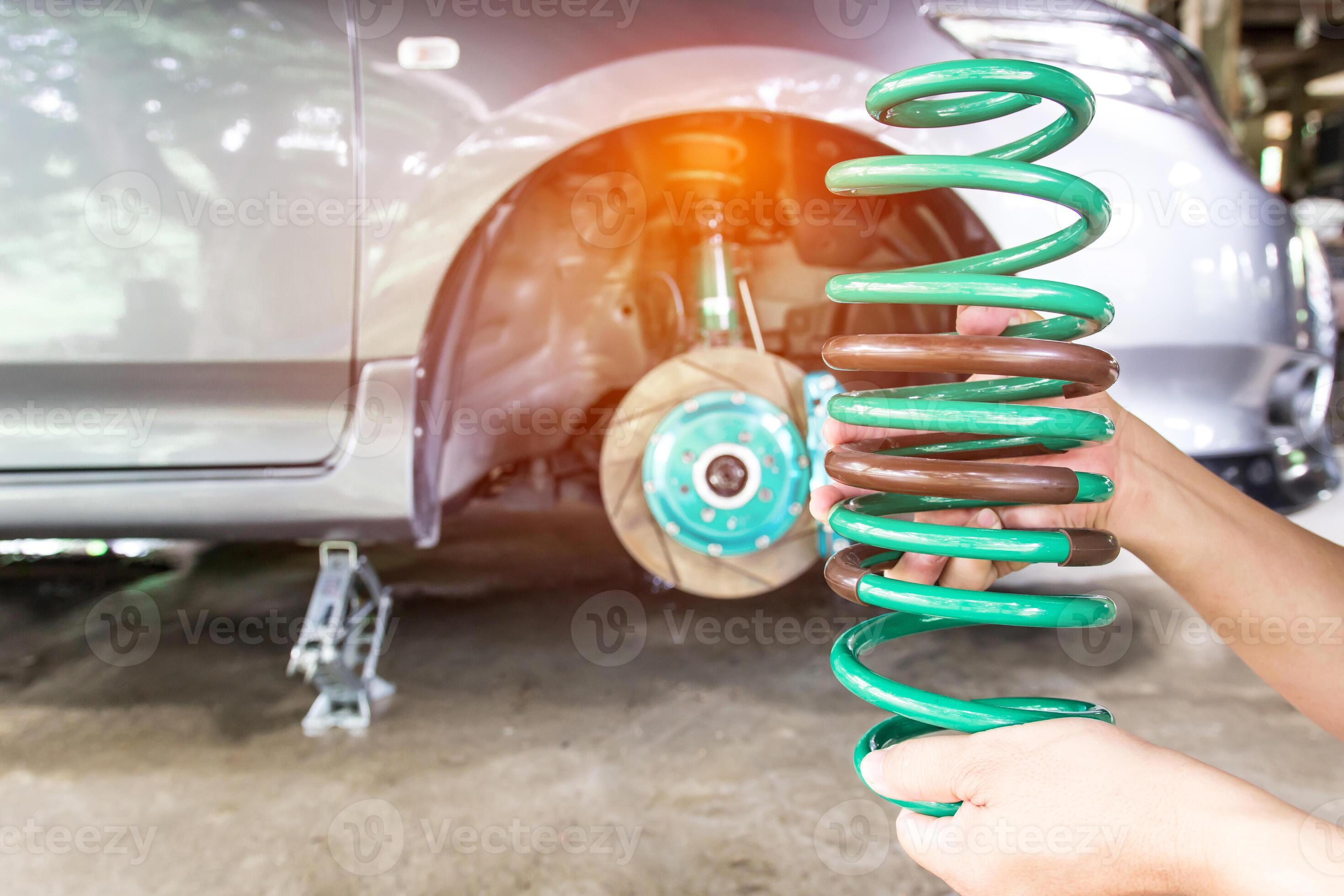 Mechanic man check and change coil spring of shock absorber on the