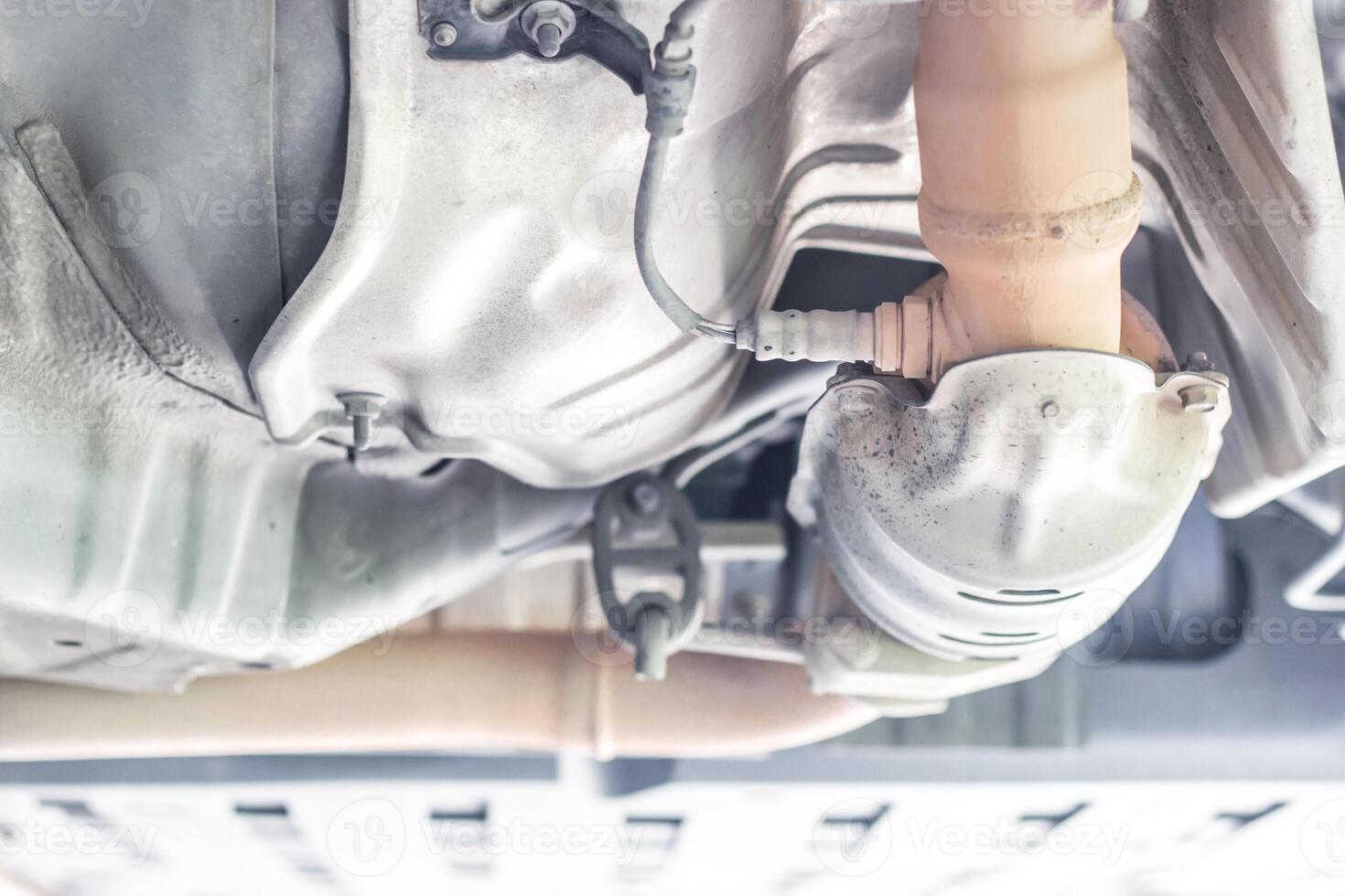 Close up oxygen sensor on Catalyst pipe of gasoline engine car on the hoist lift for service and repair in Garage shop photo
