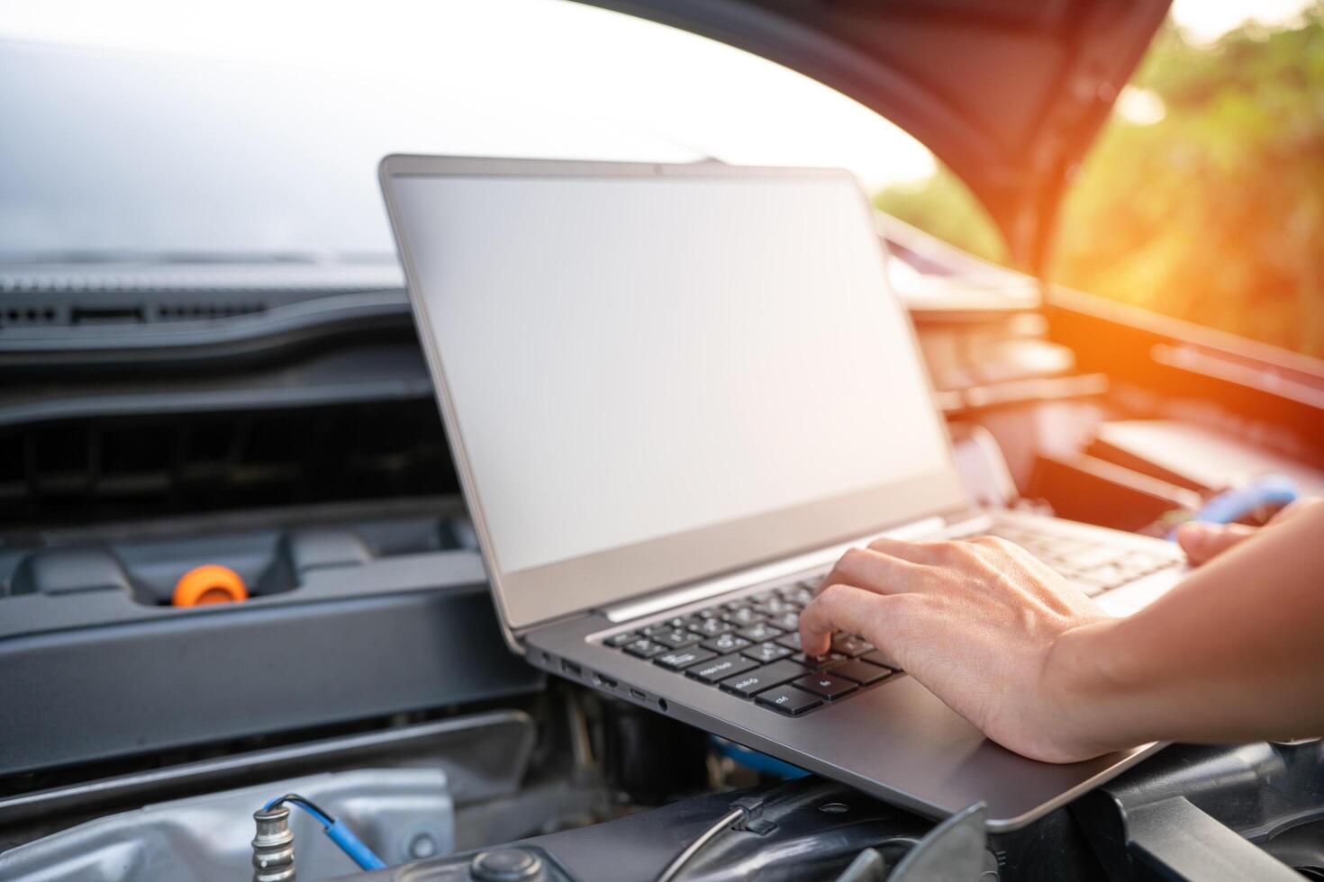 Close up hand Technician use computer Analyze car problems The parking lot on the side of the road photo