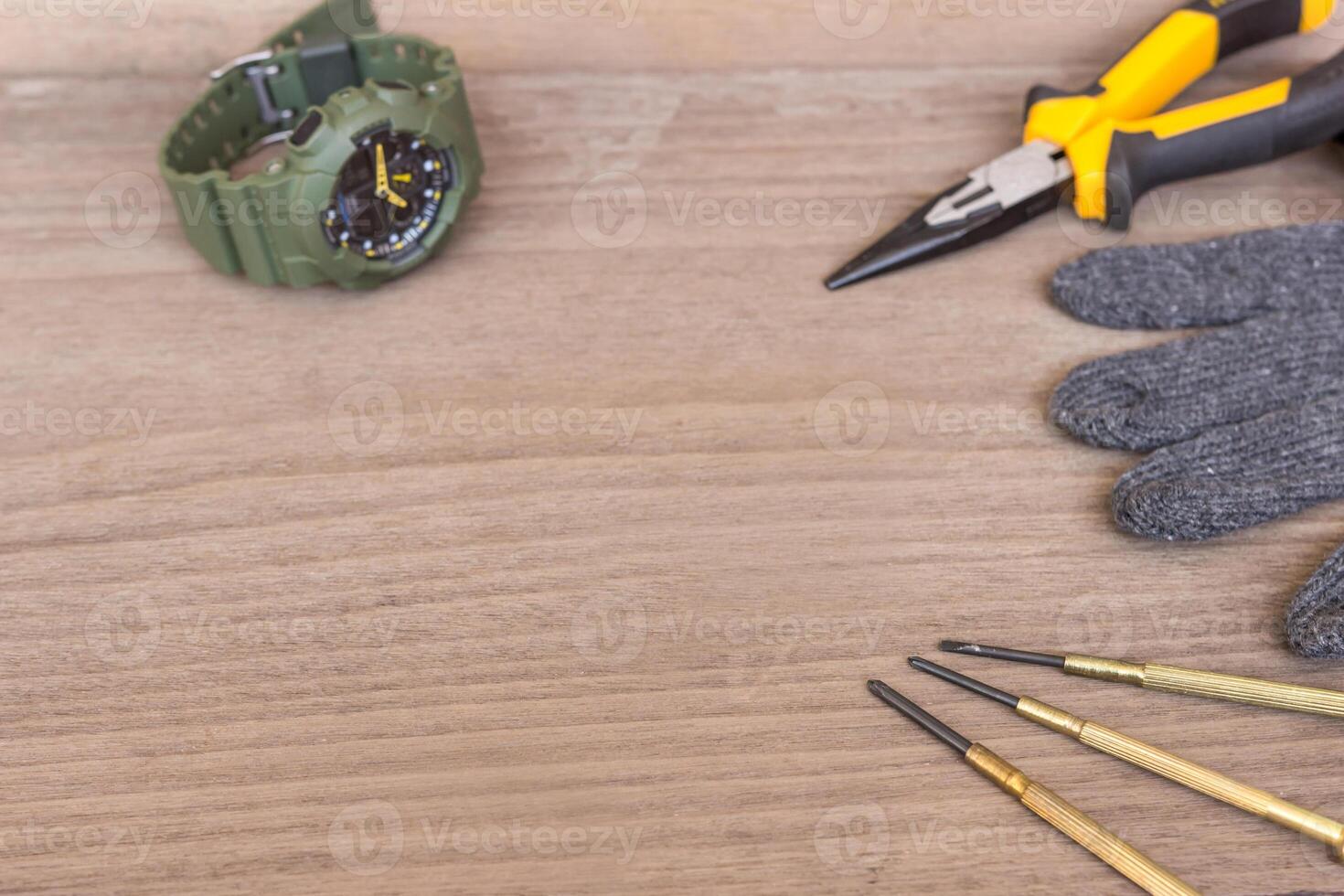 Repair concept of digital watch and screwdriver Steel pliers Gloves on the wood floor for texture and background photo