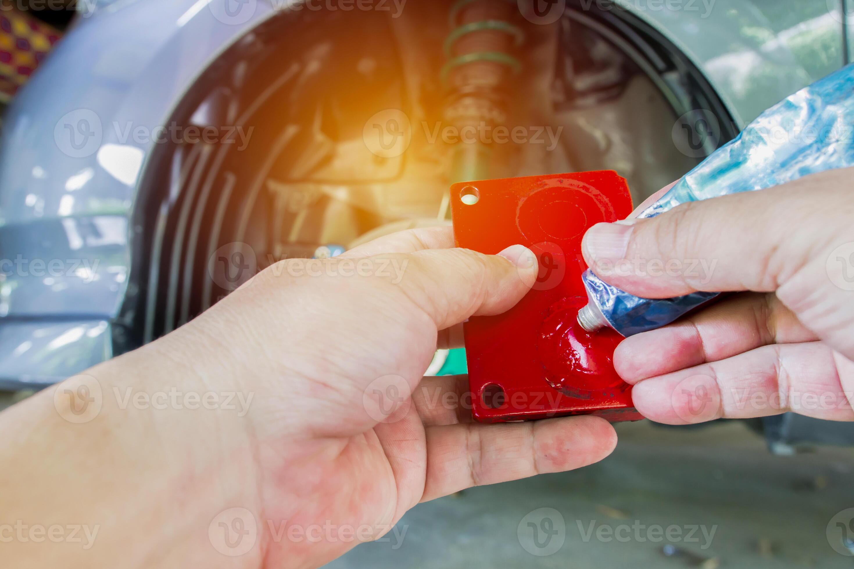 Close up hand a man apply grease on new brake pad of car for Lubricate and reduce noise in
